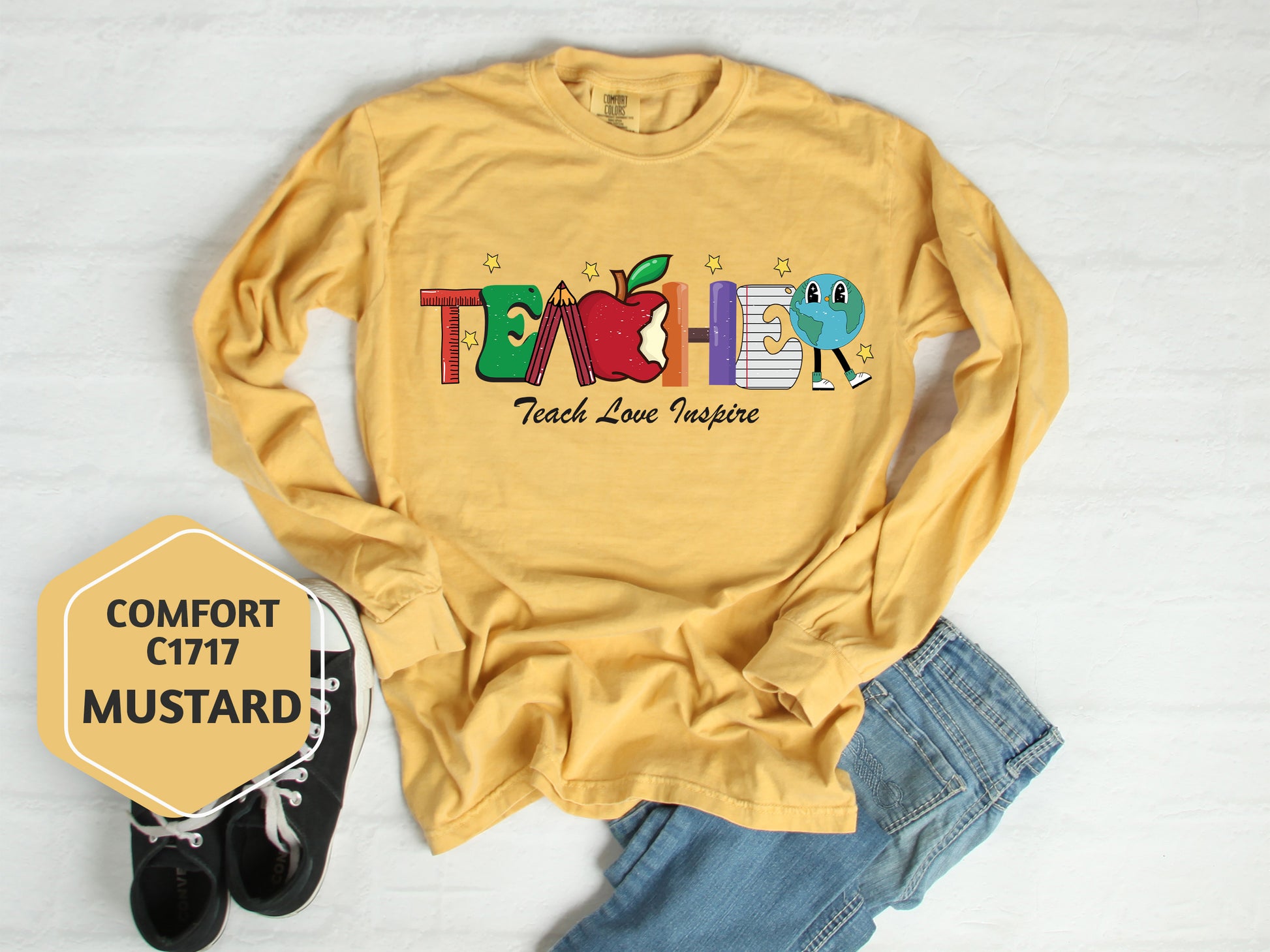 a t - shirt that says teacher next to a pair of jeans
