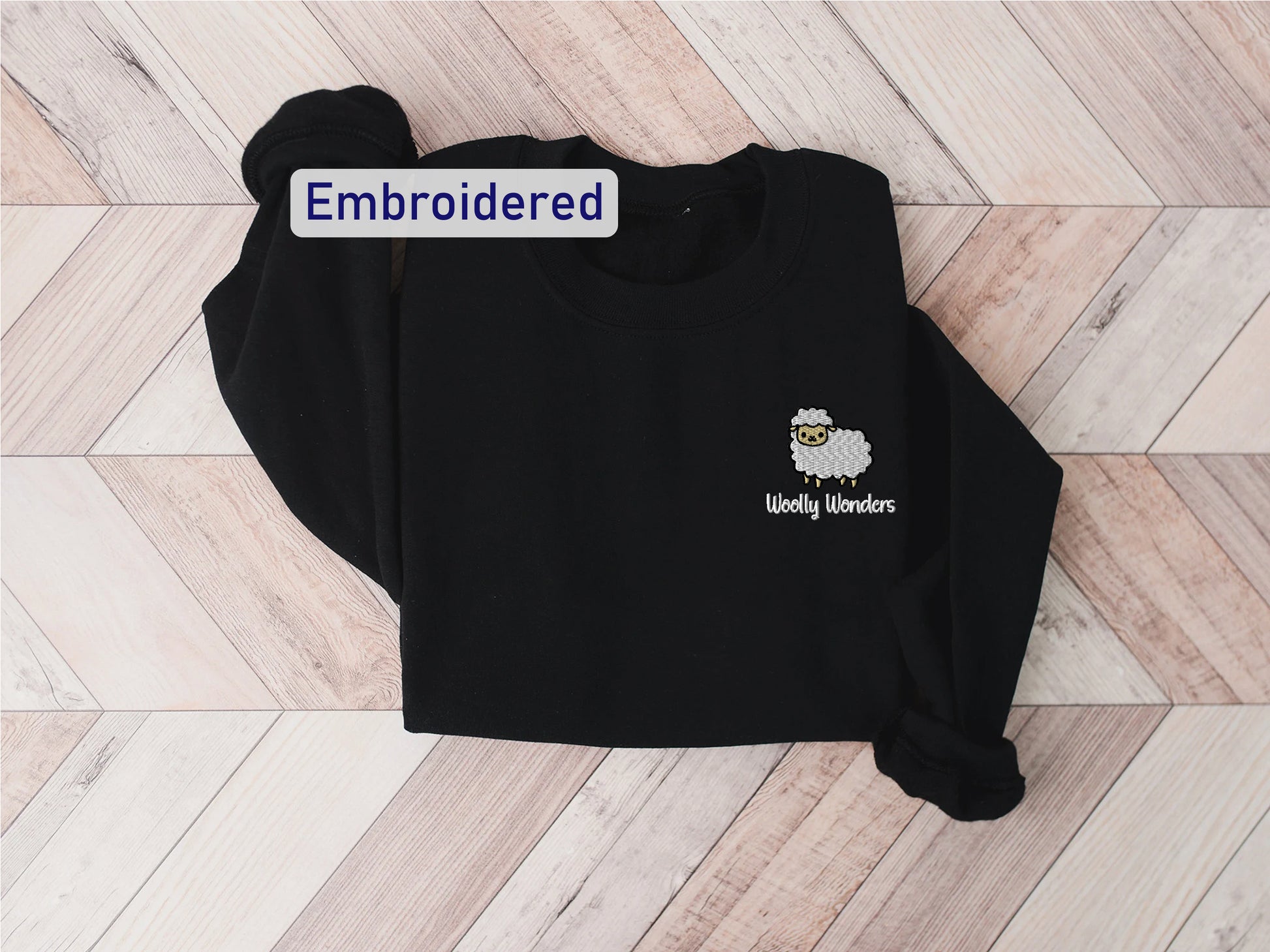 a black sweatshirt with an embroidered sheep on it