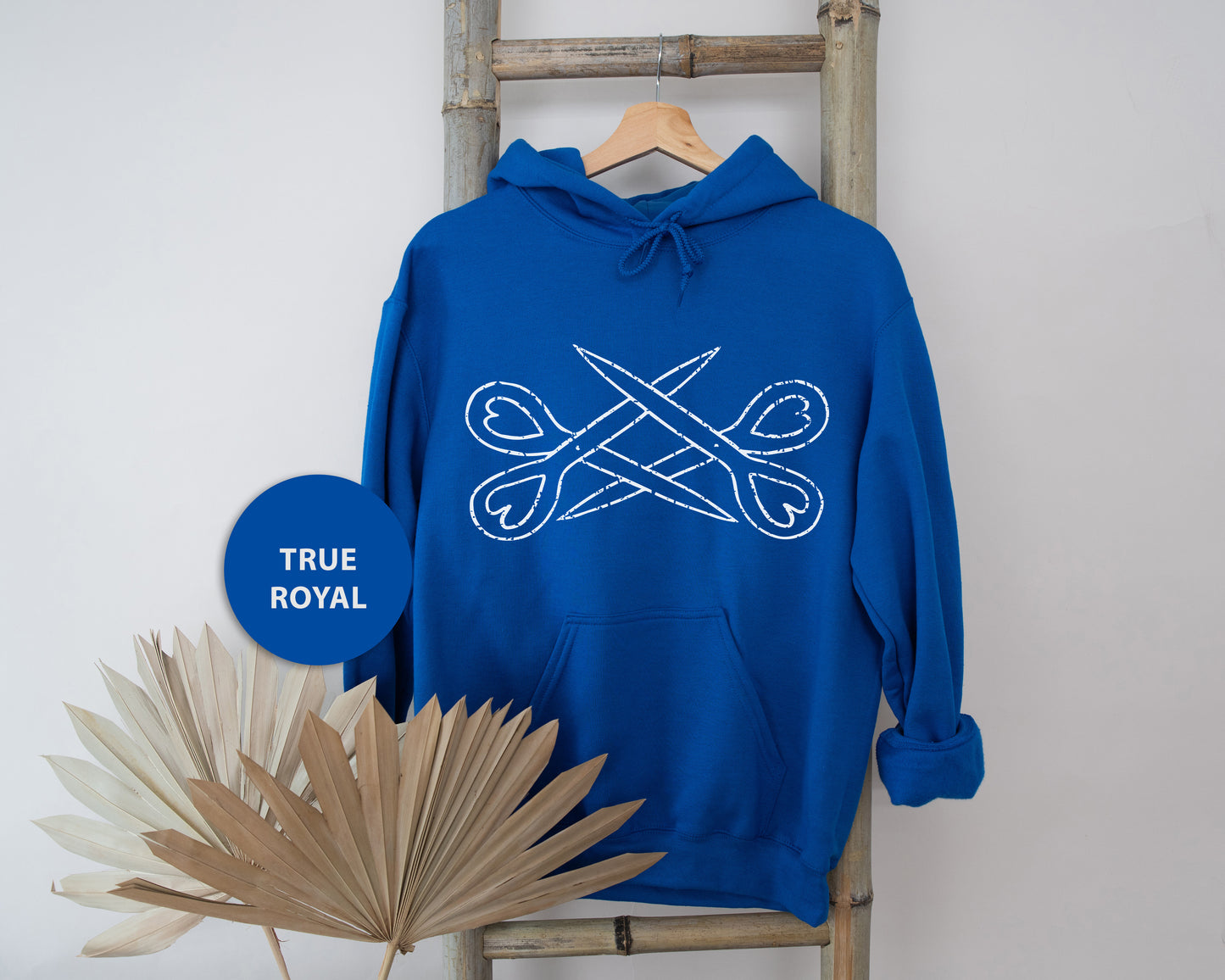 a blue hoodie with a pair of scissors on it