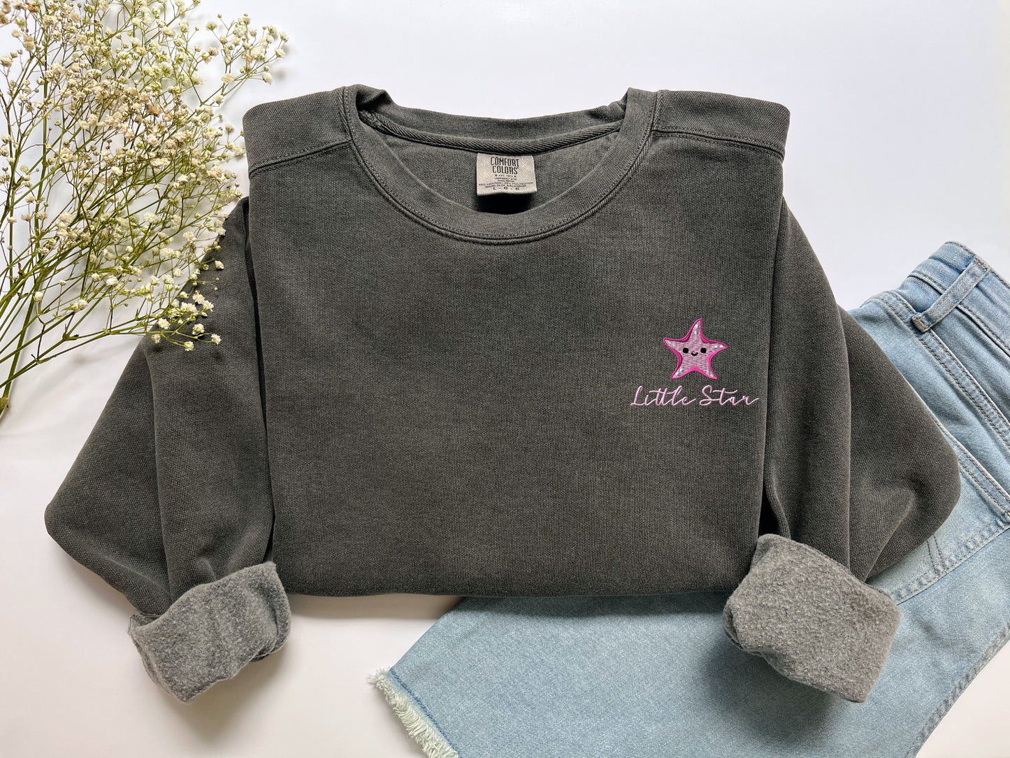 a gray shirt with a pink star on it
