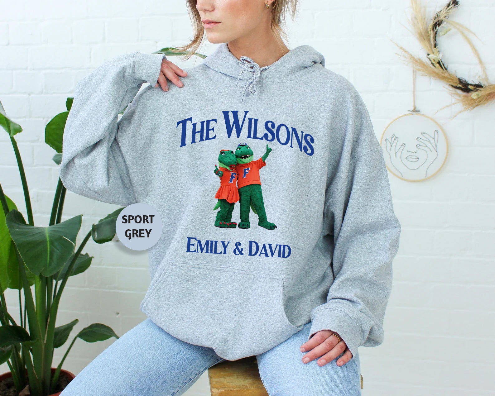 a woman sitting on a stool wearing a sweatshirt