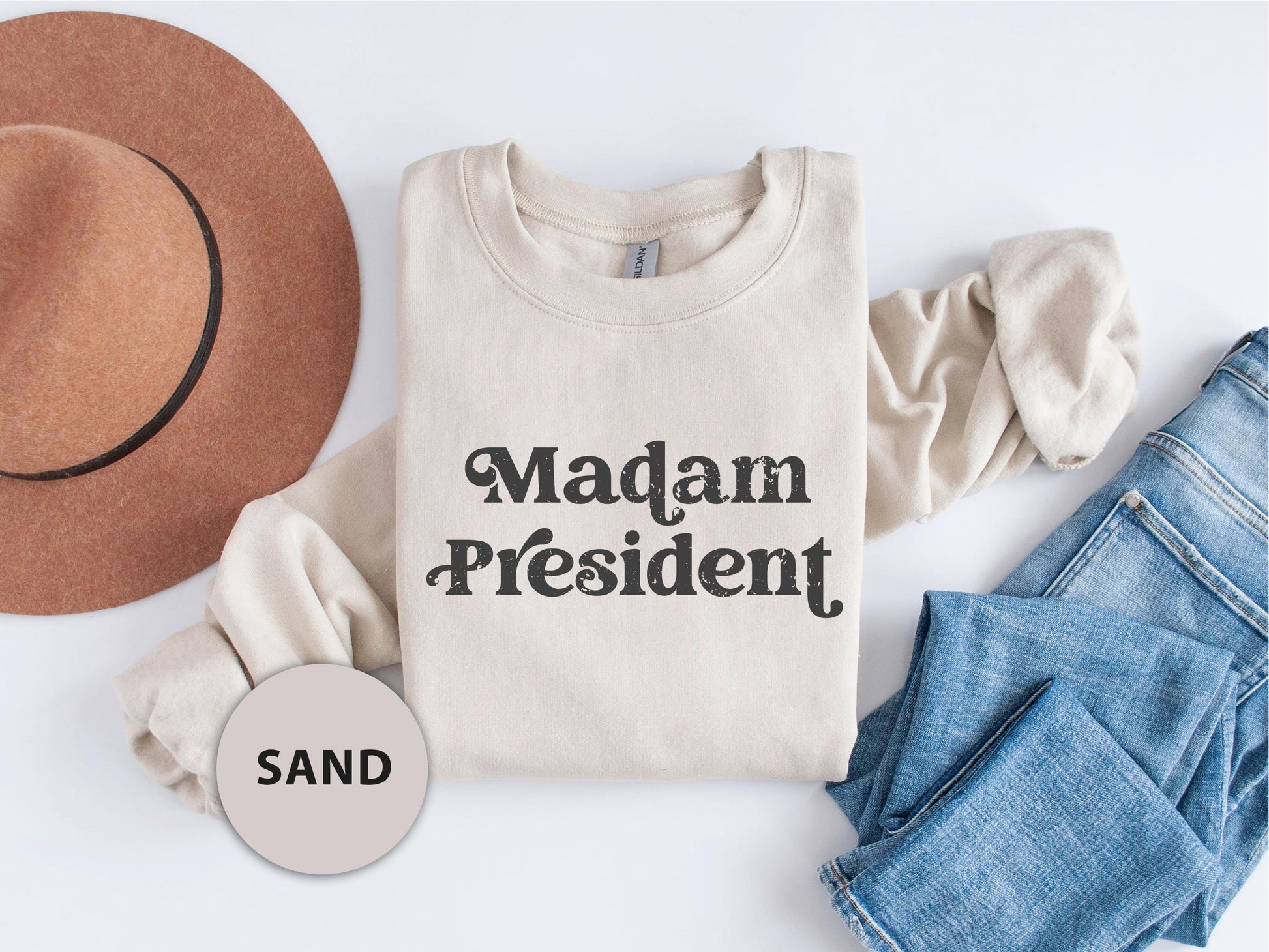 a shirt that says madam president next to a hat