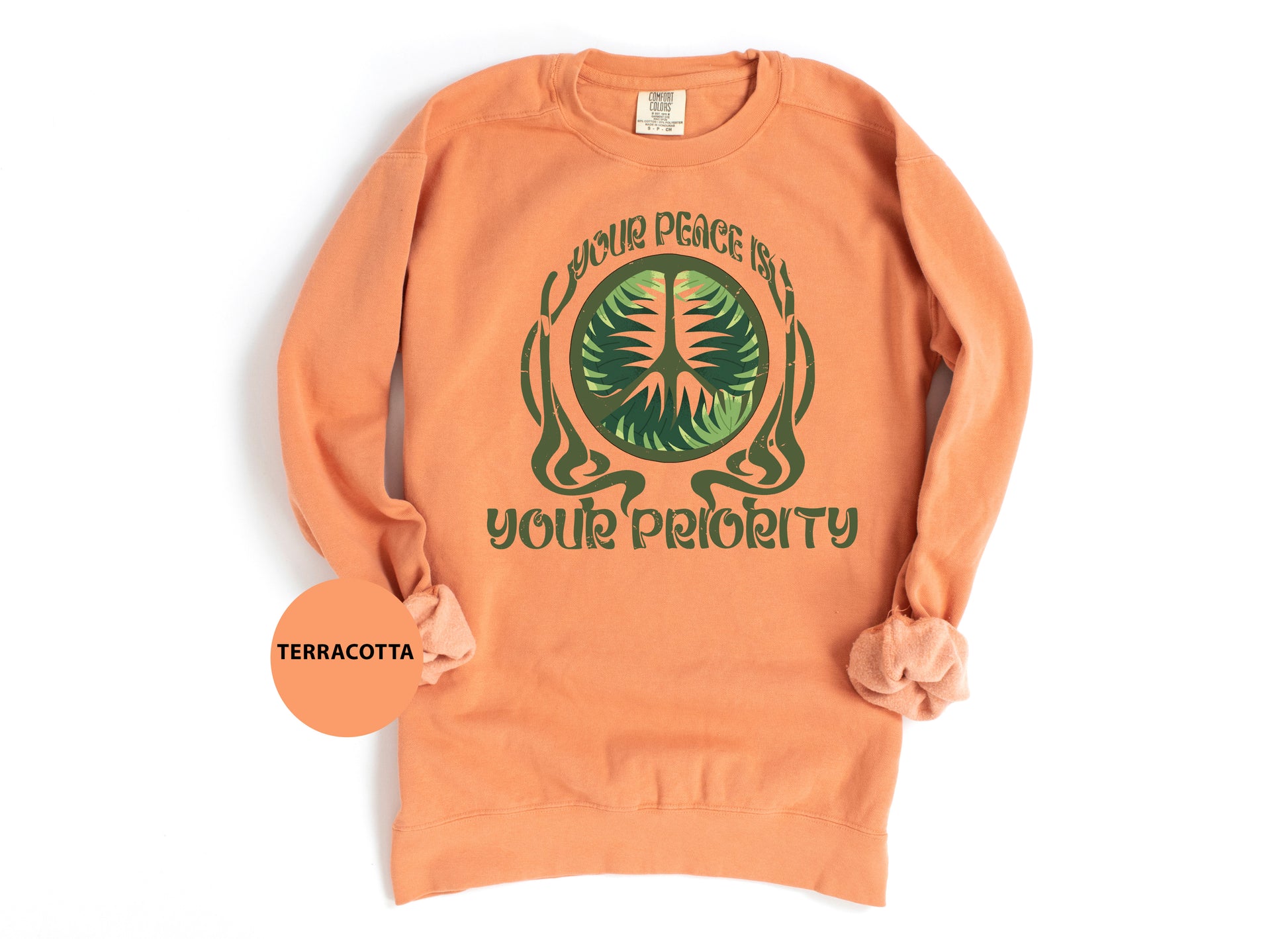 an orange sweatshirt with a green tree on it