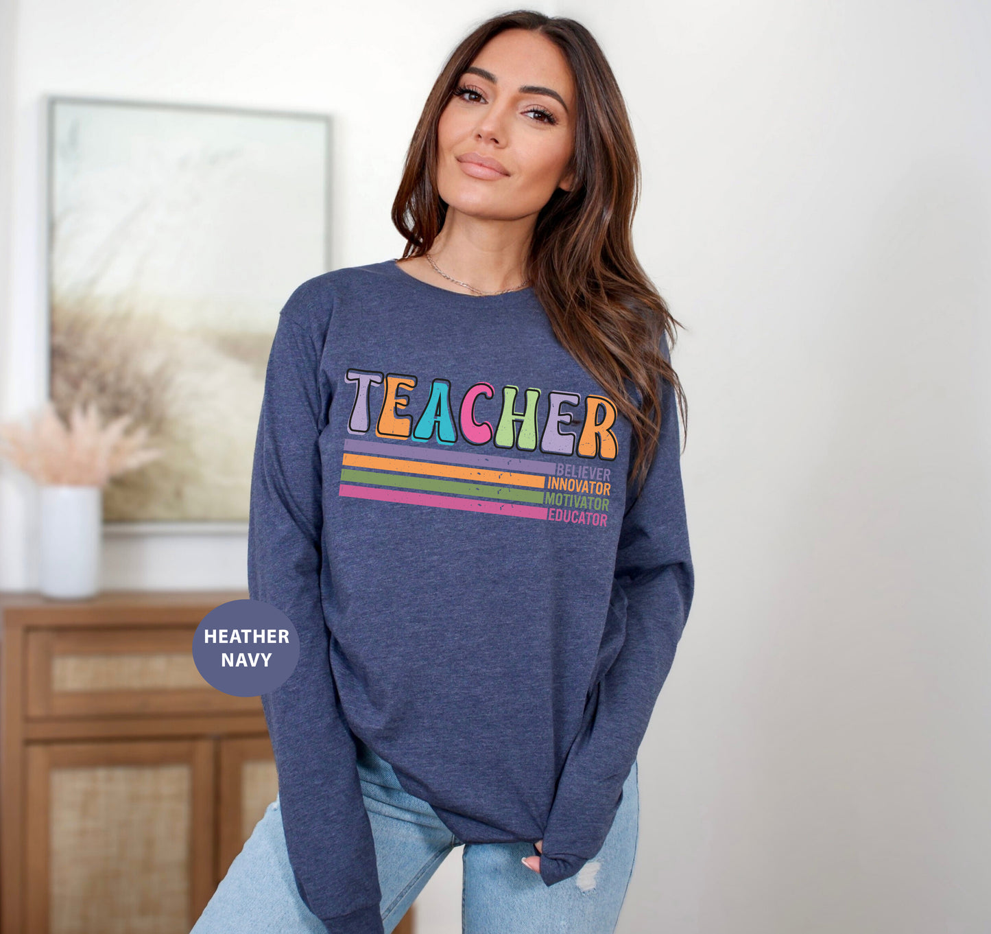 a woman standing in a room wearing a teacher sweatshirt