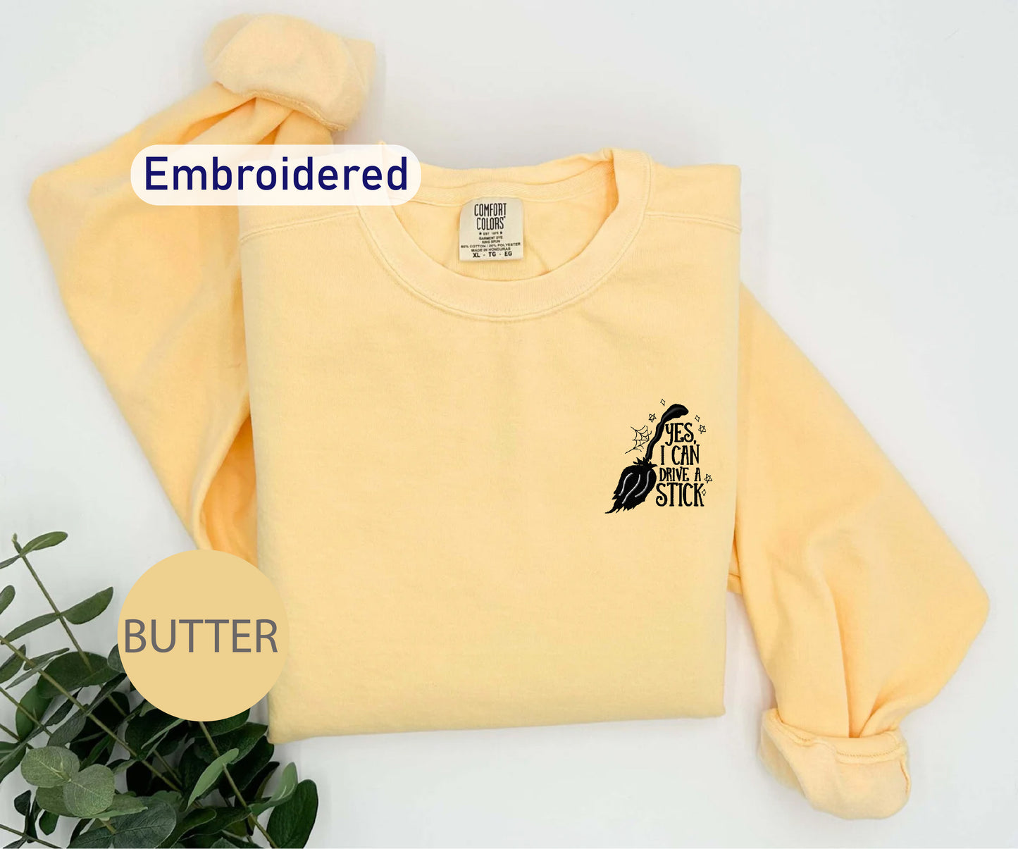 a yellow sweatshirt with a black bird embroidered on it