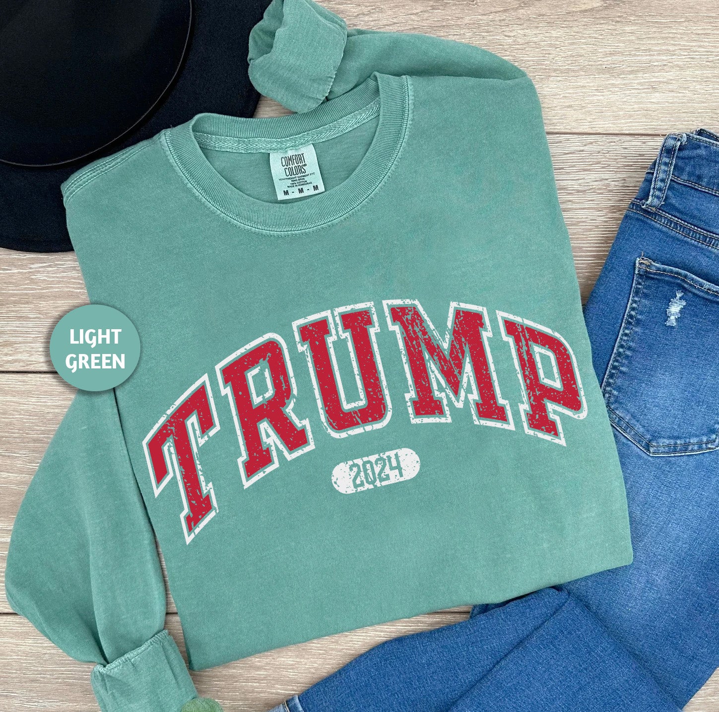 a green shirt with the word trump on it next to jeans and a hat