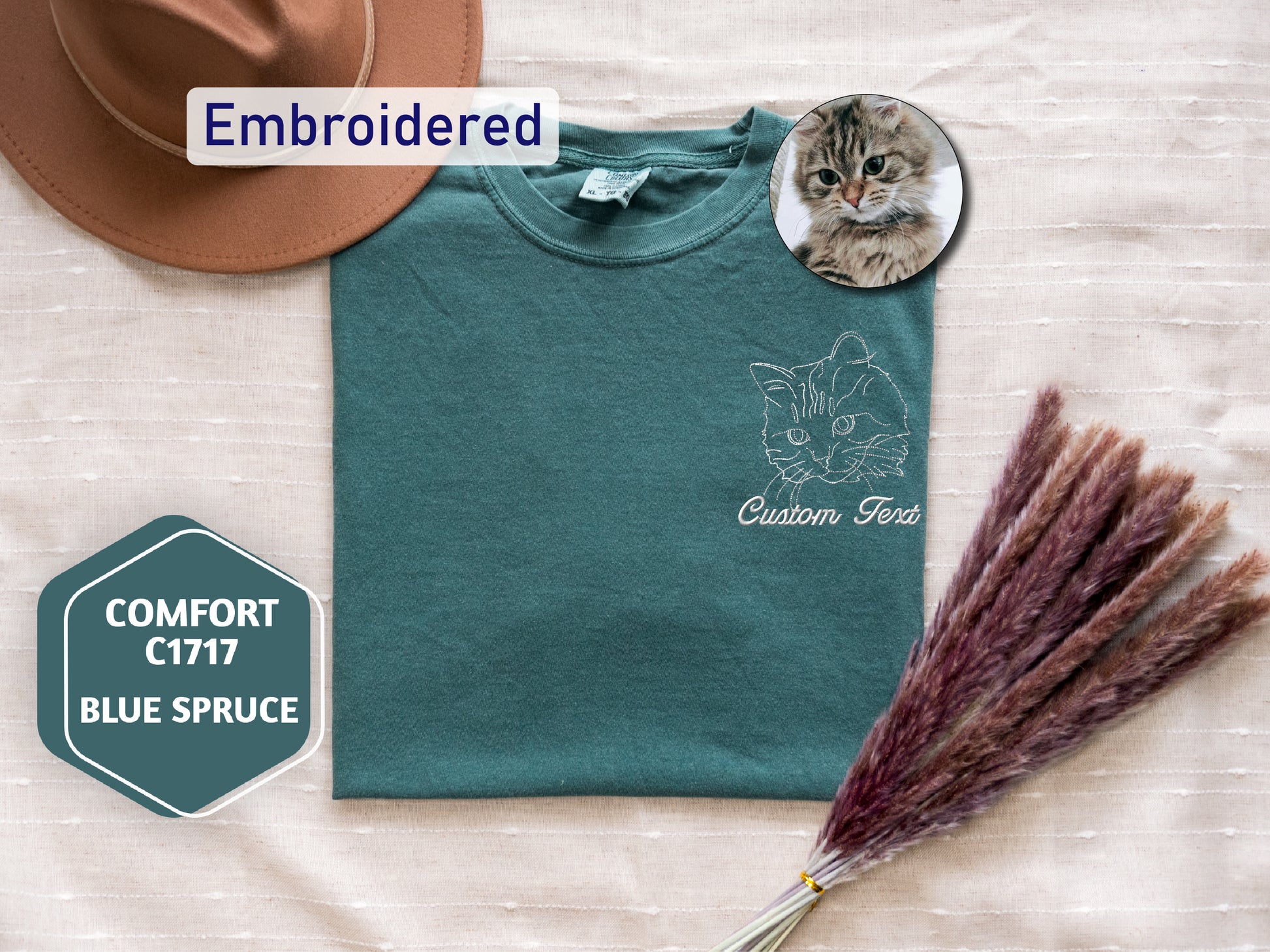 a t - shirt with a cat on it and a broom next to it