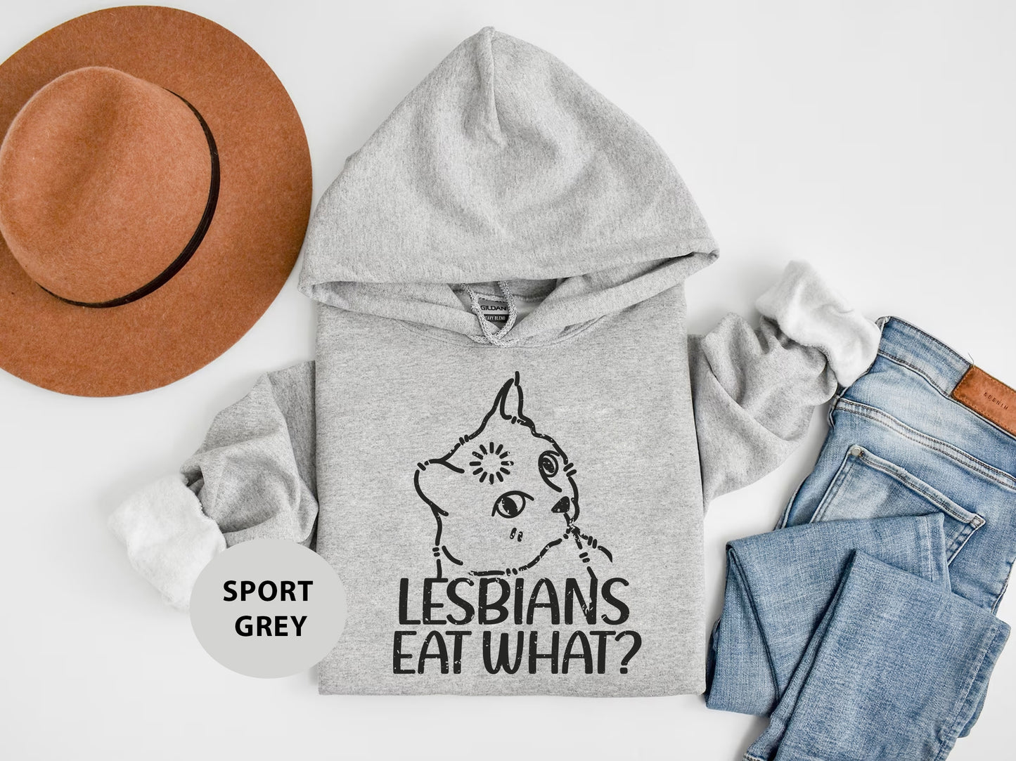 a gray hoodie with the words lesbians eat what on it next to a