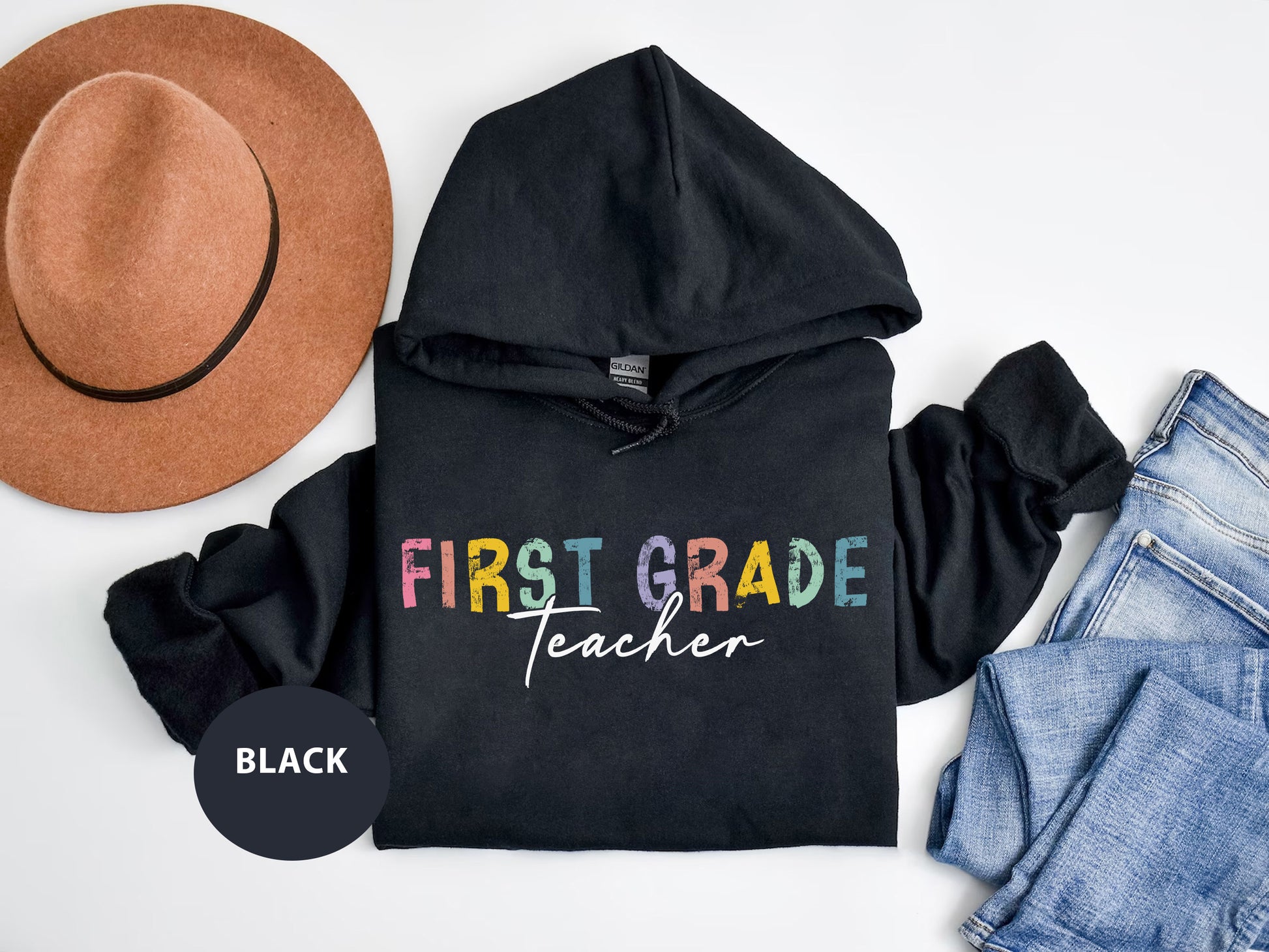 a black hoodie with the words first grade teacher on it