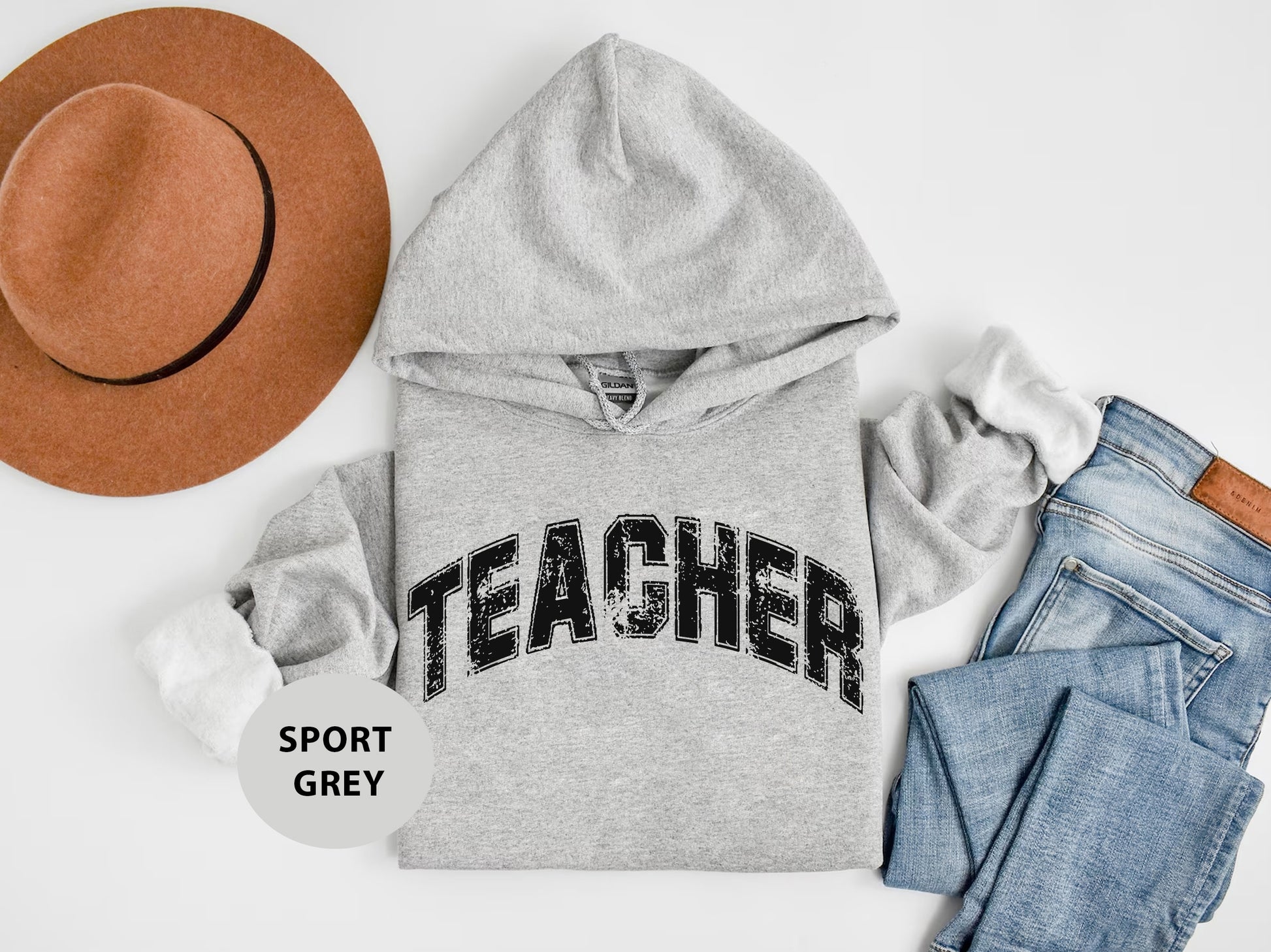 a hat, sweatshirt, jeans, and a pair of shoes on a white background