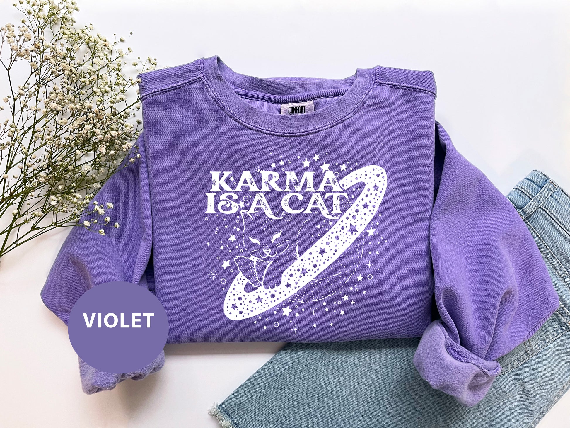 a purple shirt that says karma is a cat