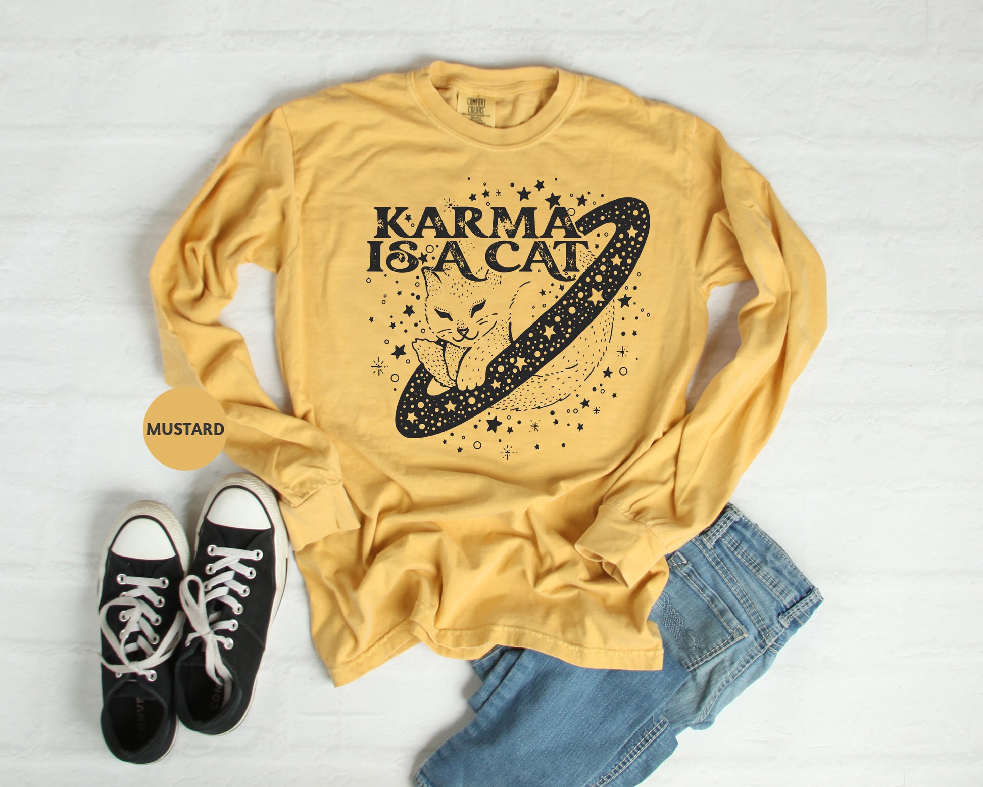 a t - shirt that says karma is a cat next to a pair of black