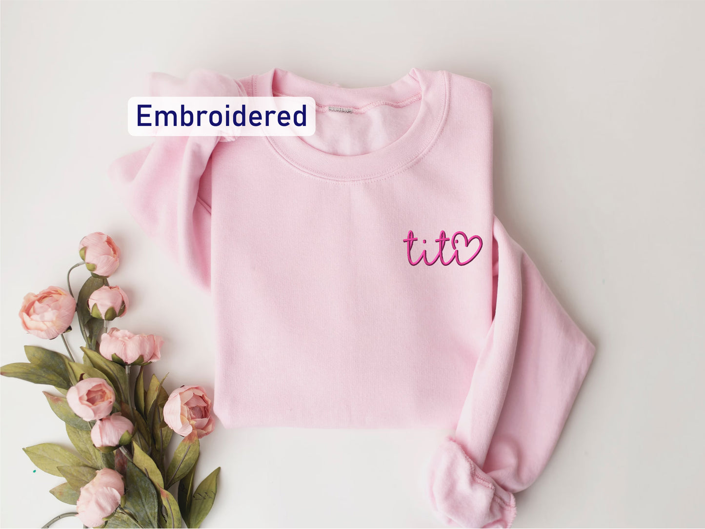 a pink sweater with the words embroidered on it