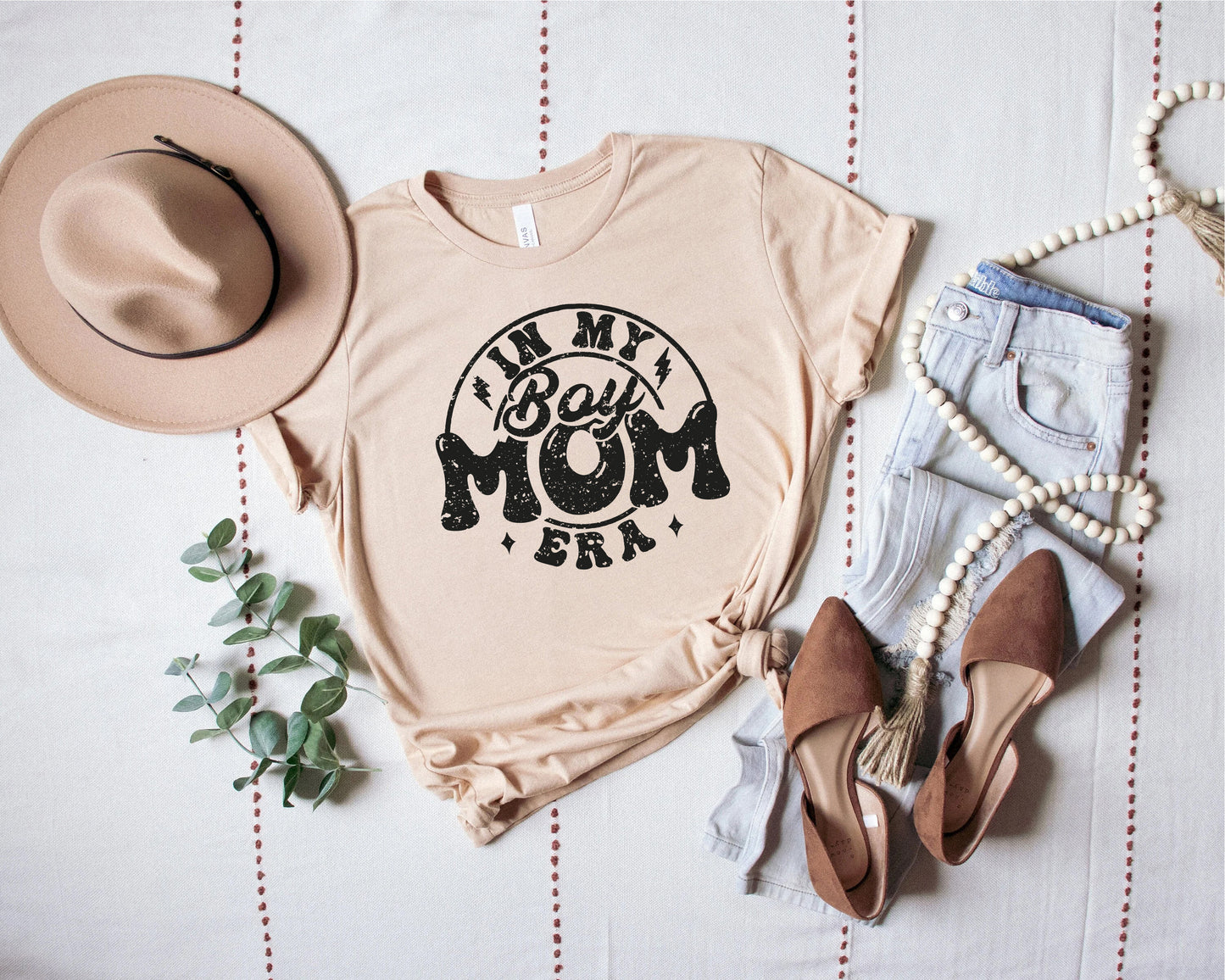a t - shirt that says i'm my mom and a hat next to