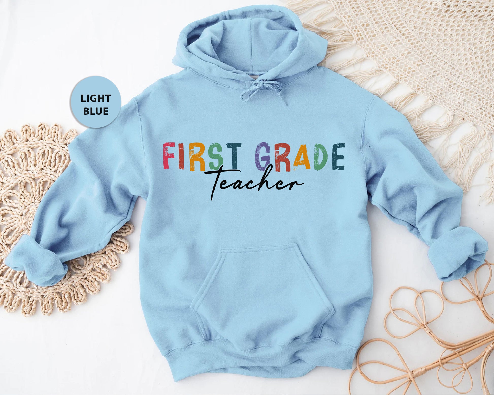 a blue sweatshirt with the words first grade teacher on it