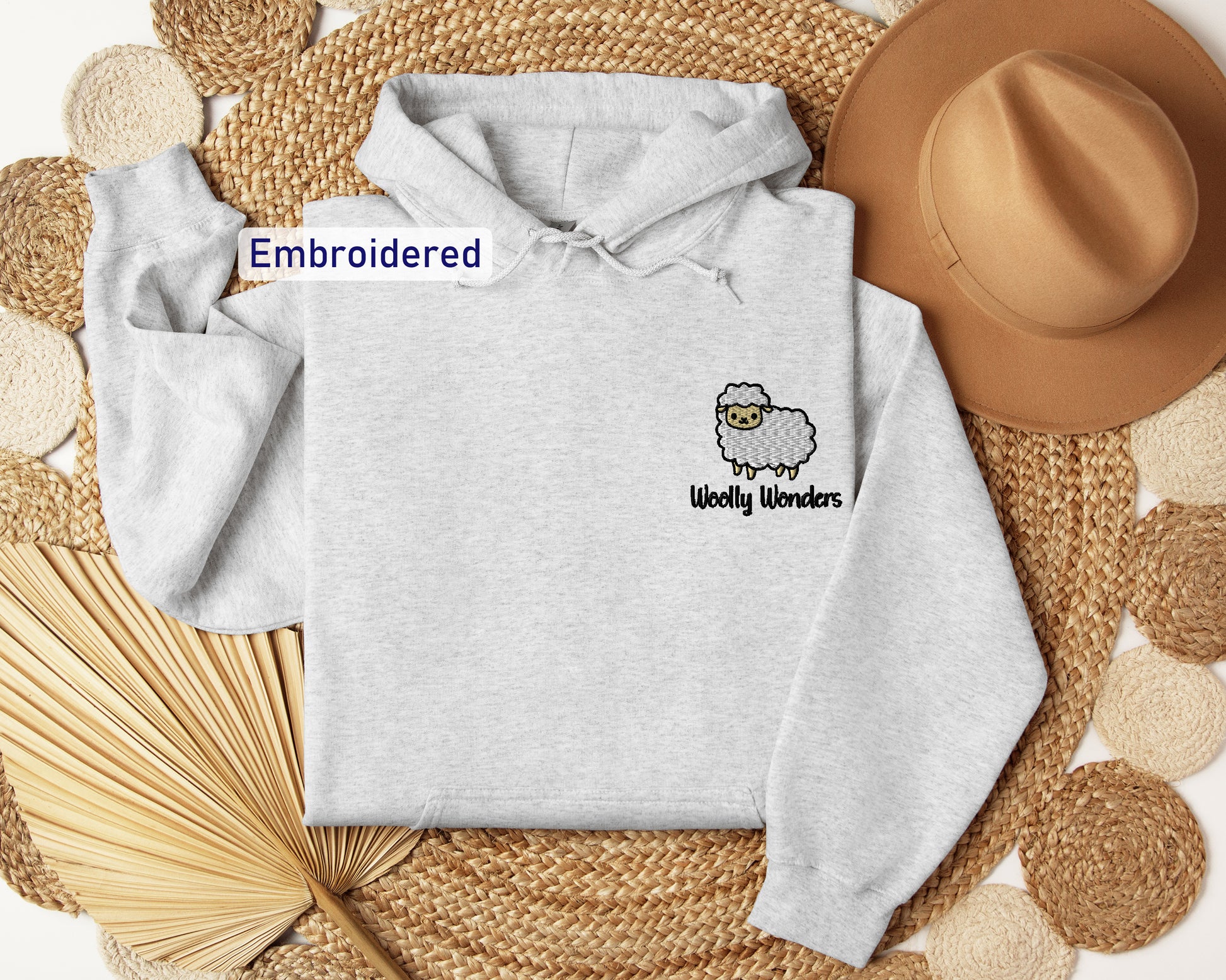 a white sweatshirt with a sheep embroidered on it