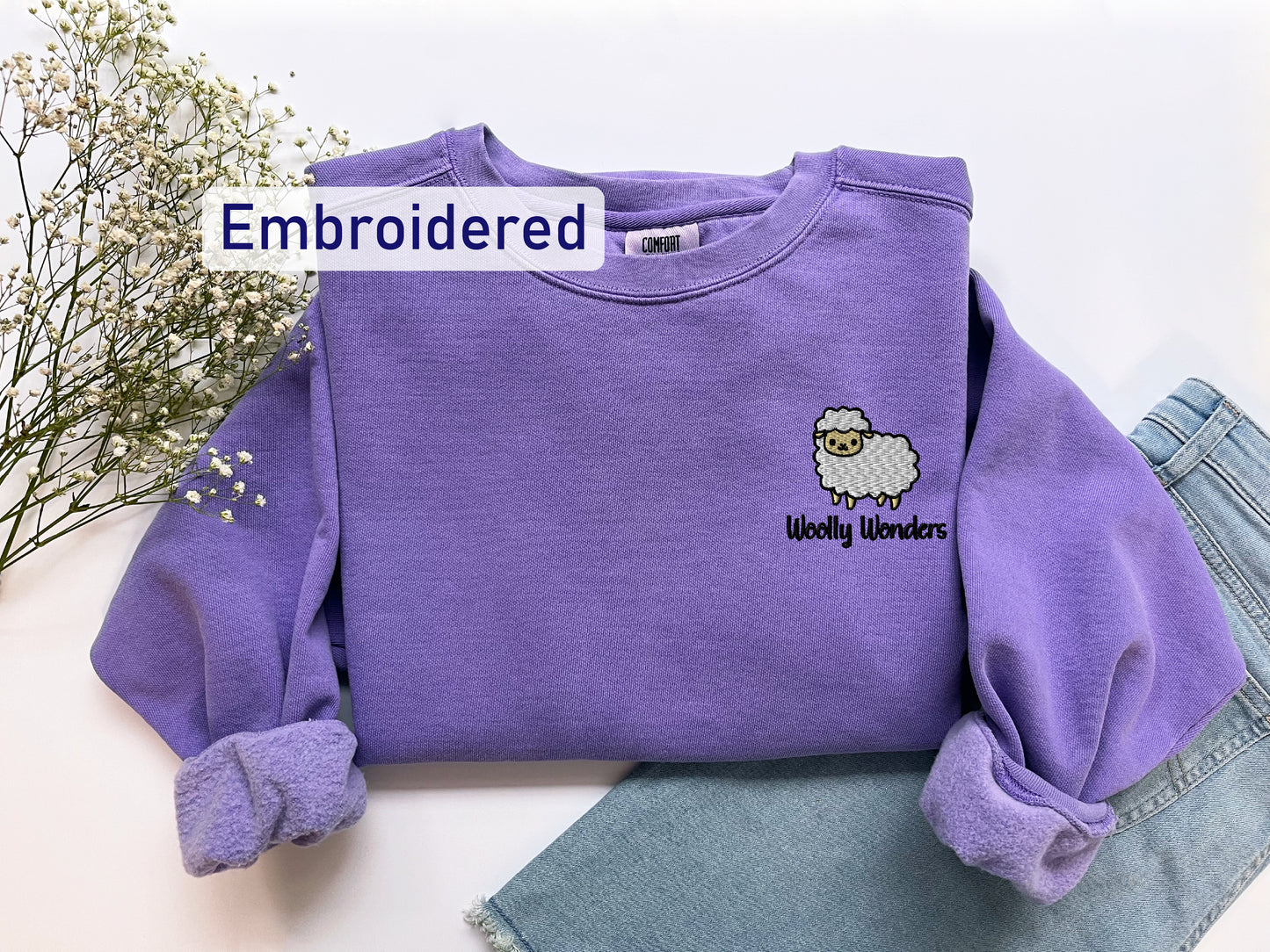 a purple shirt with a sheep embroidered on it
