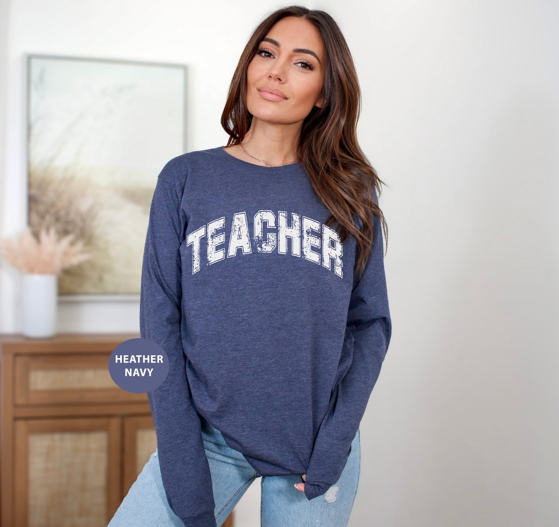 a woman wearing a blue sweatshirt with the words teacher on it