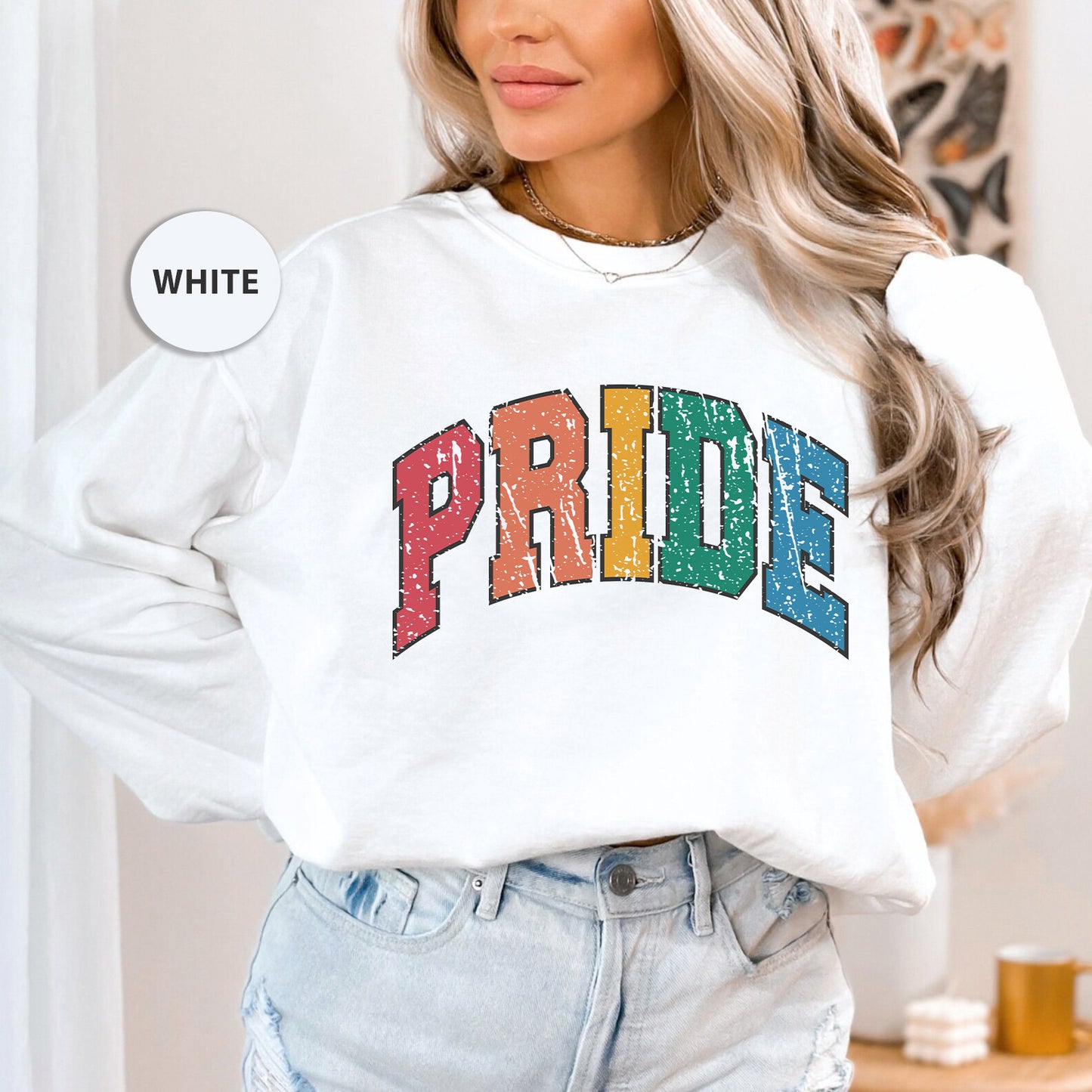 a woman wearing a white sweatshirt with the word pride printed on it