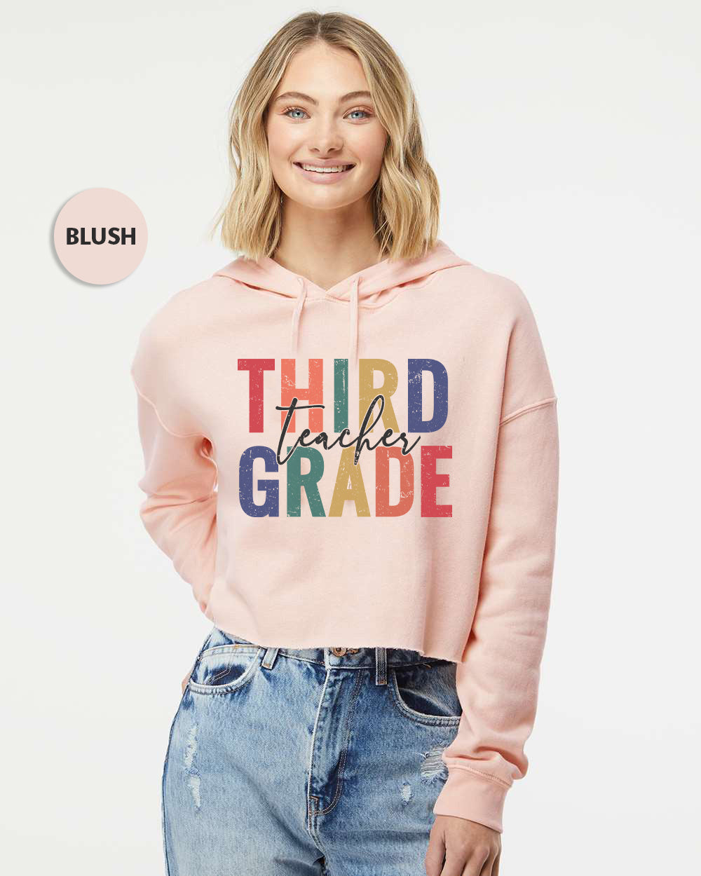 a woman wearing a pink hoodie that says third grade
