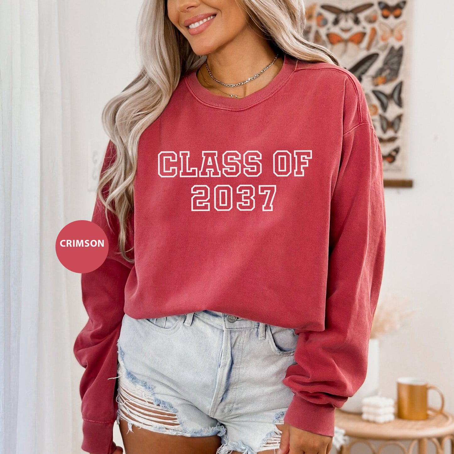 a woman wearing a red sweatshirt that says class of 2021