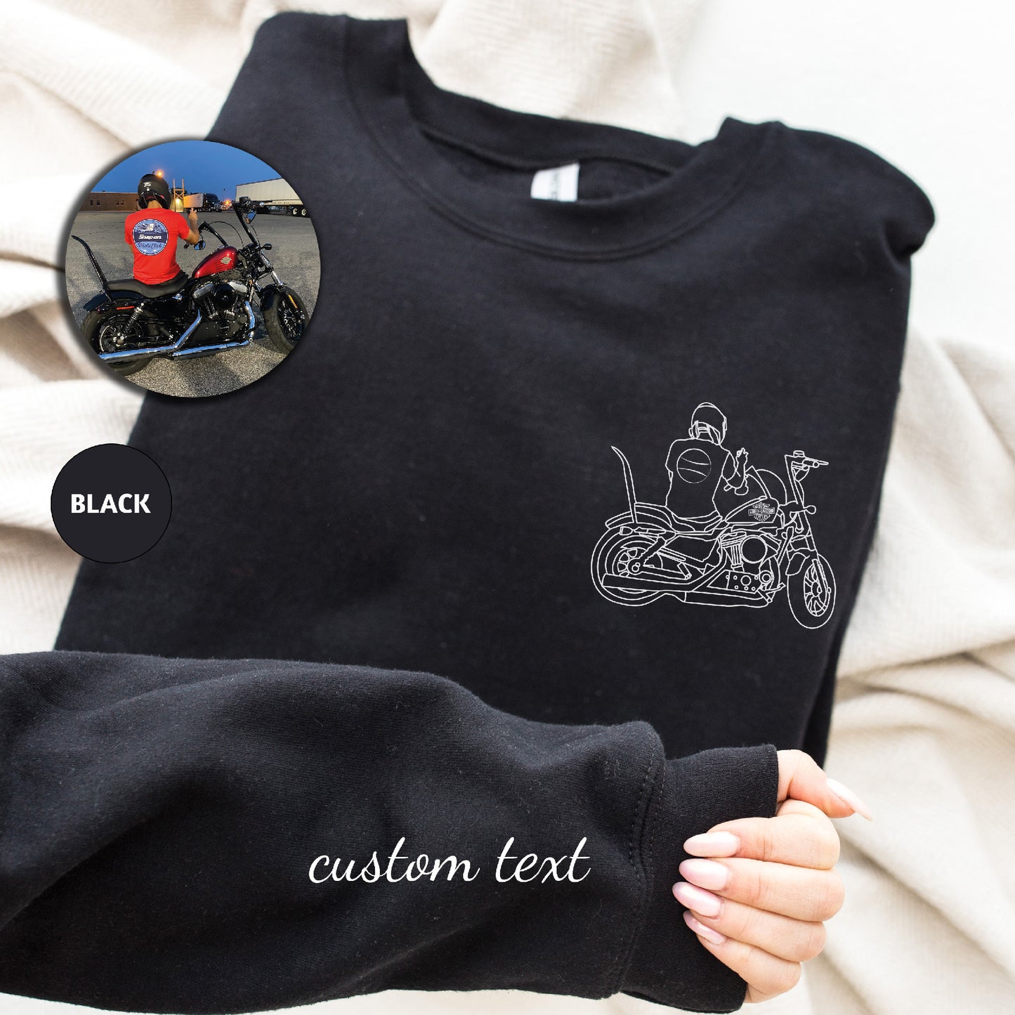 a person holding a black shirt with a picture of a motorcycle on it