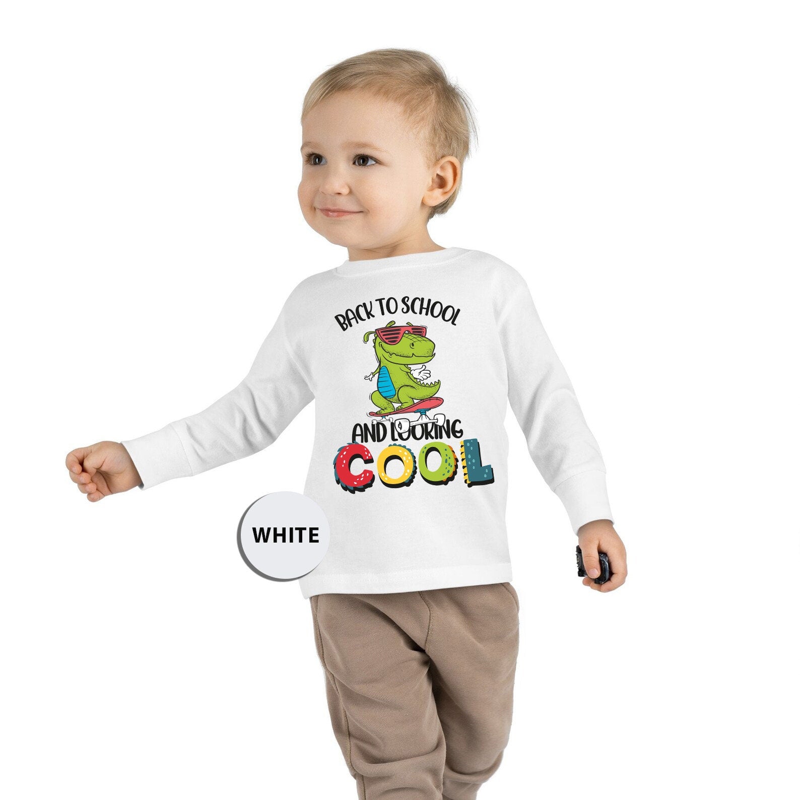 a little boy wearing a long sleeve tee shirt