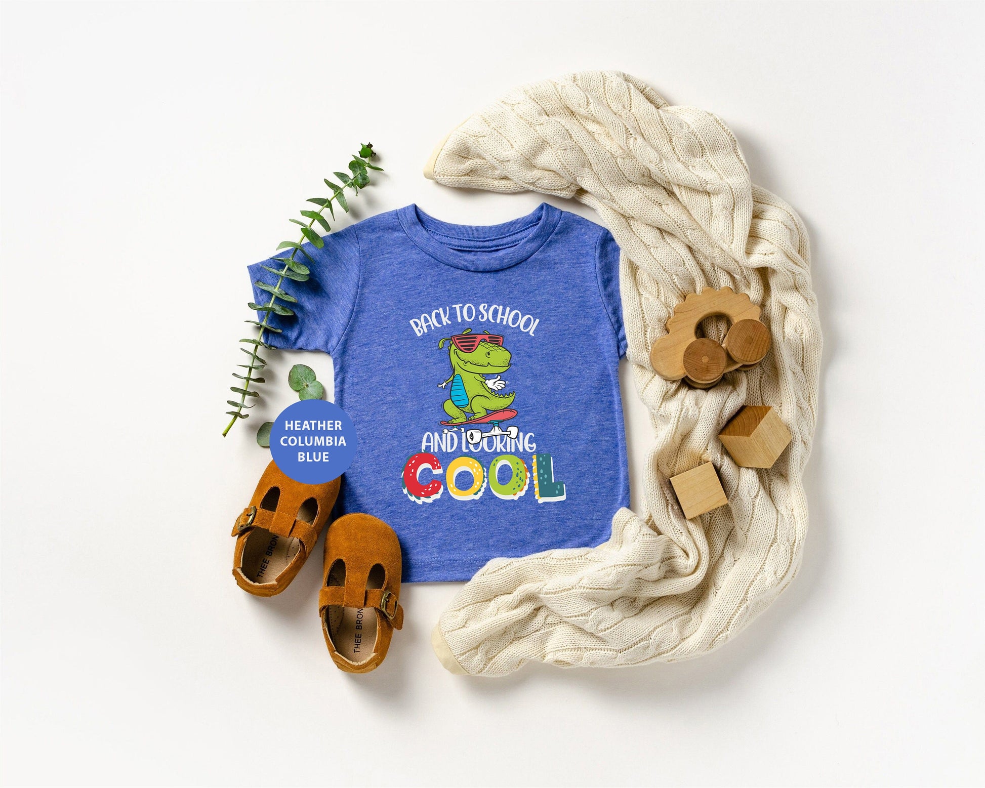 a child's t - shirt, shoes, and a scarf on a white