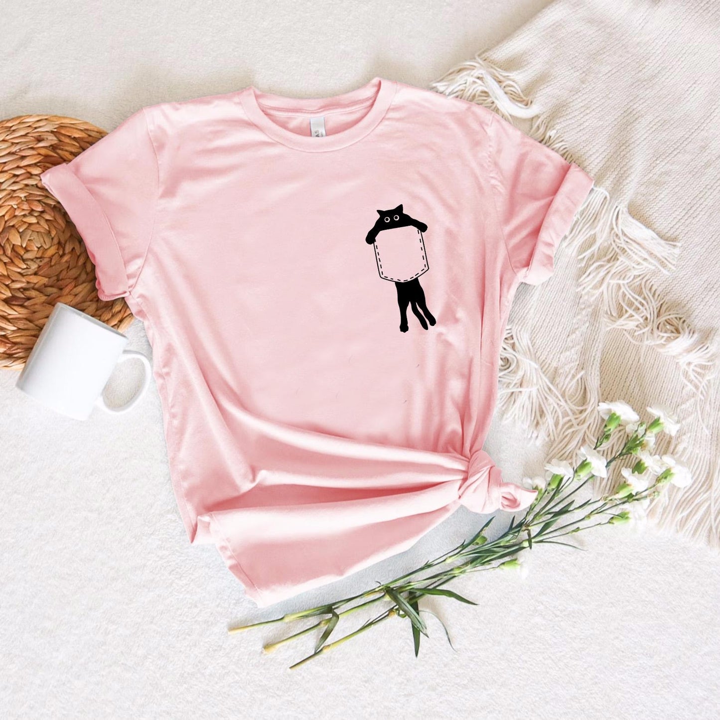a pink t - shirt with a picture of a man holding a sign