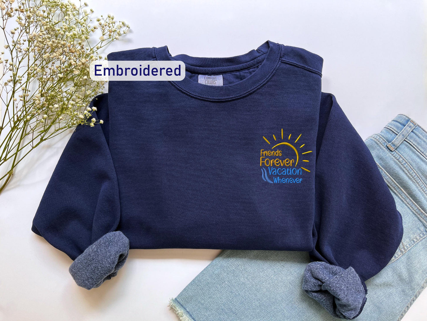 a blue sweatshirt with a sun embroidered on it