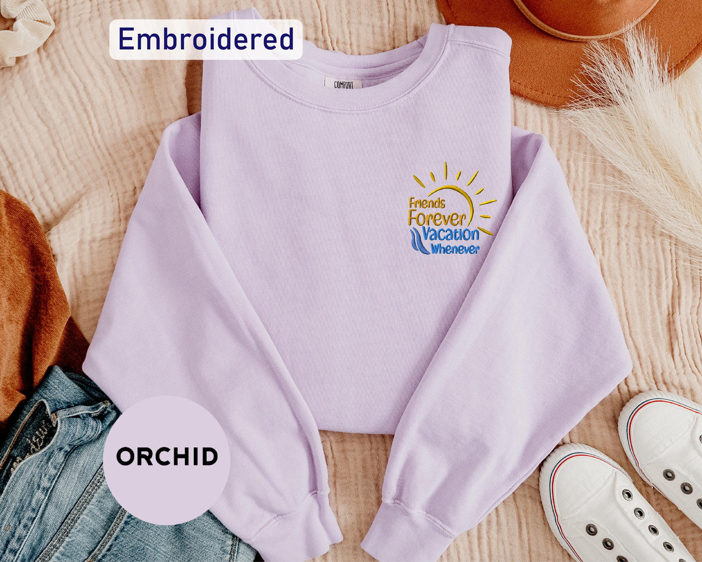 a purple shirt with a logo on it and a pair of shoes next to it