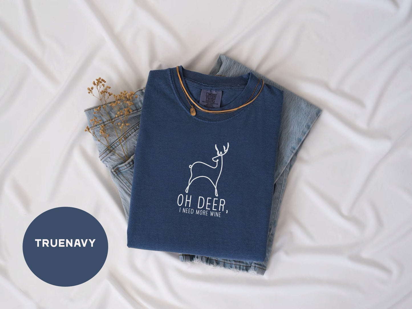 a t - shirt with a deer on it next to a pair of jeans