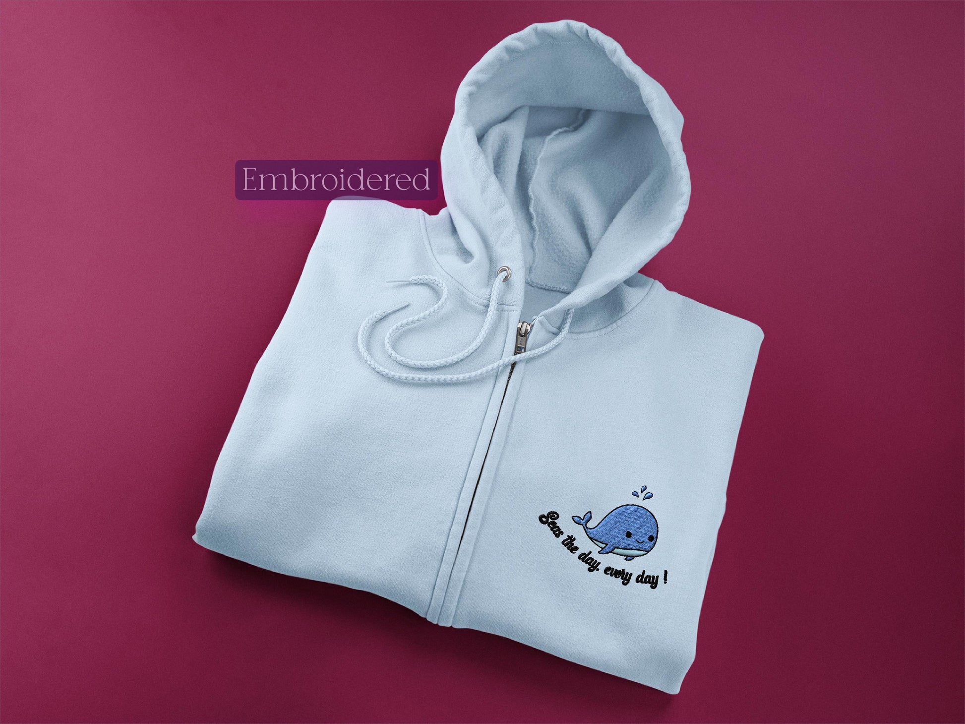 a white hoodie with a whale embroidered on it