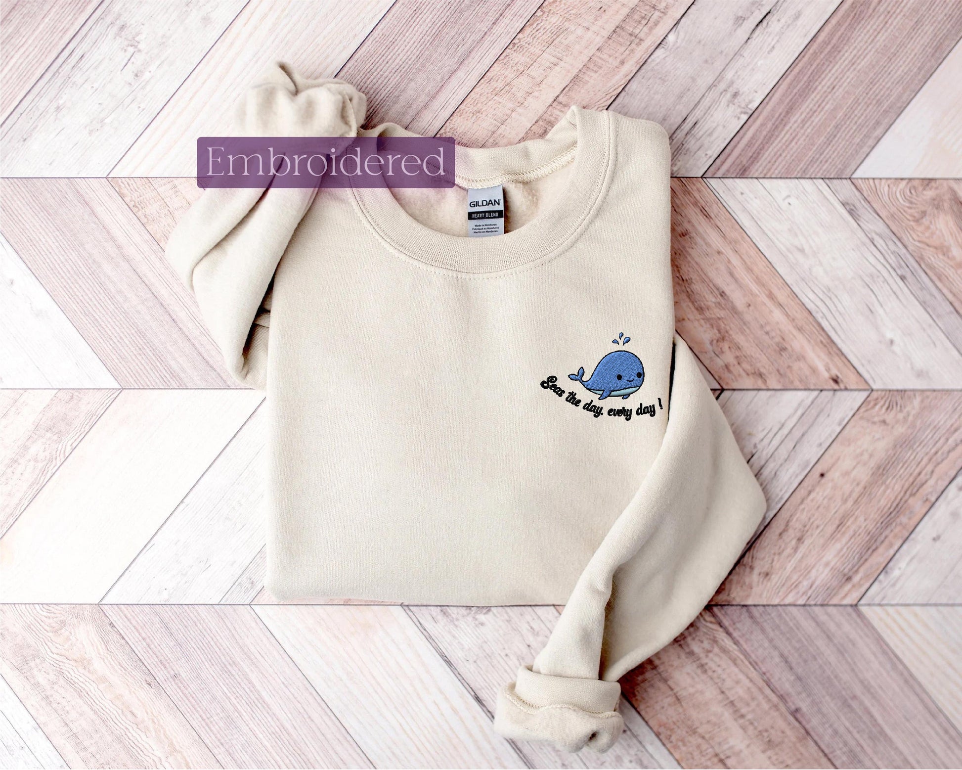 a white sweater with a whale embroidered on it