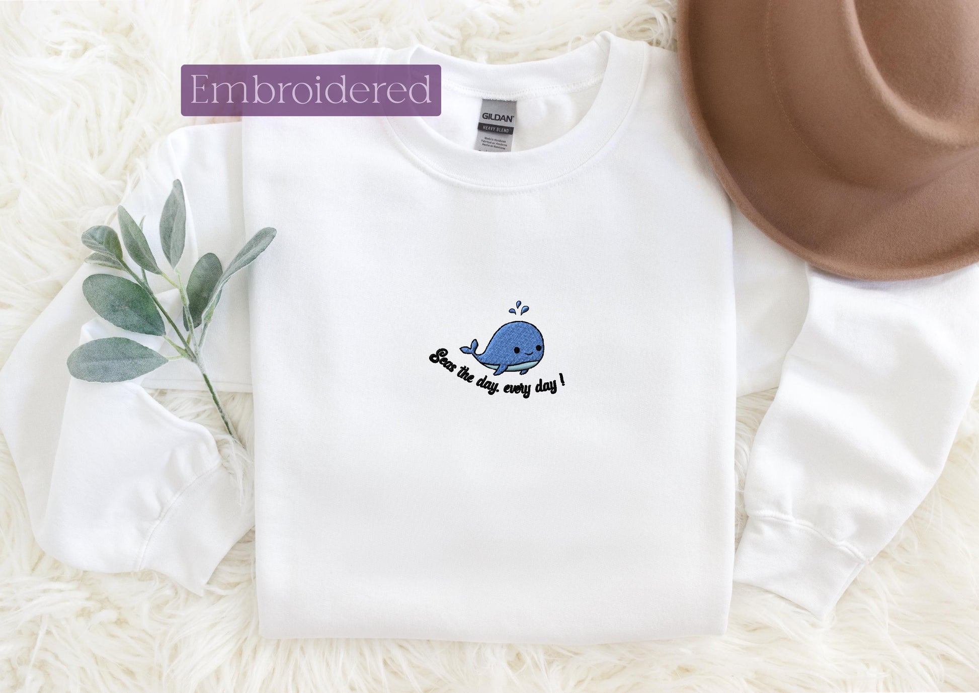 a white shirt with a blue whale embroidered on it