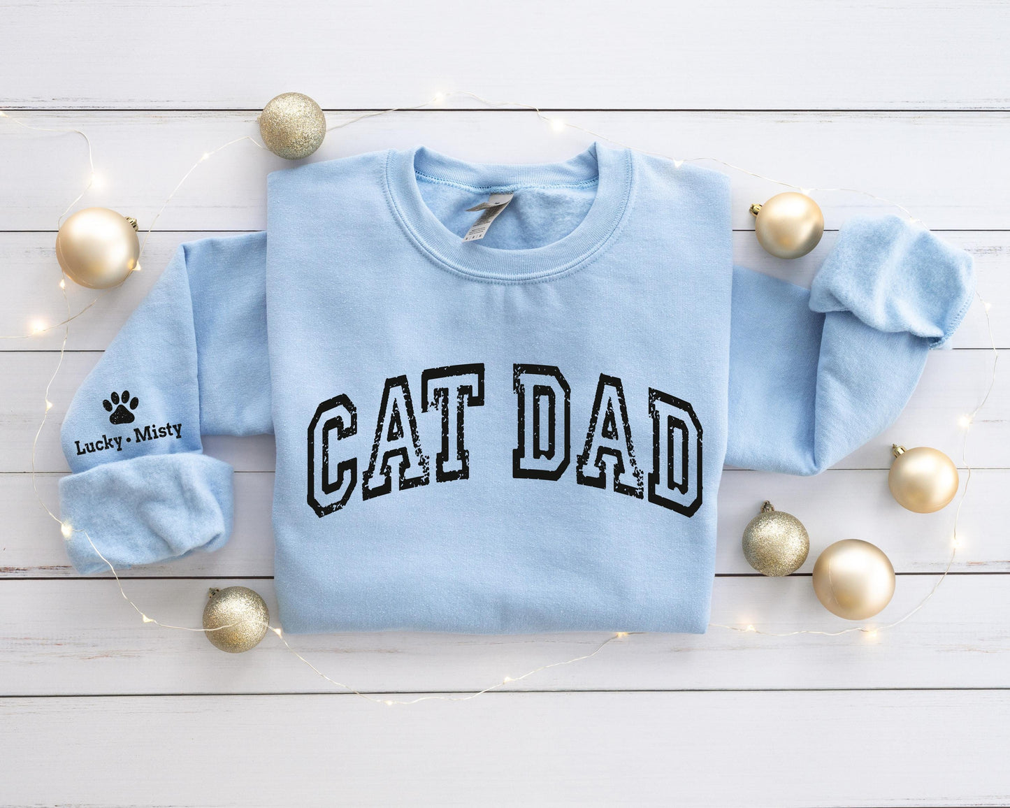 a blue sweatshirt with the word cat dad printed on it