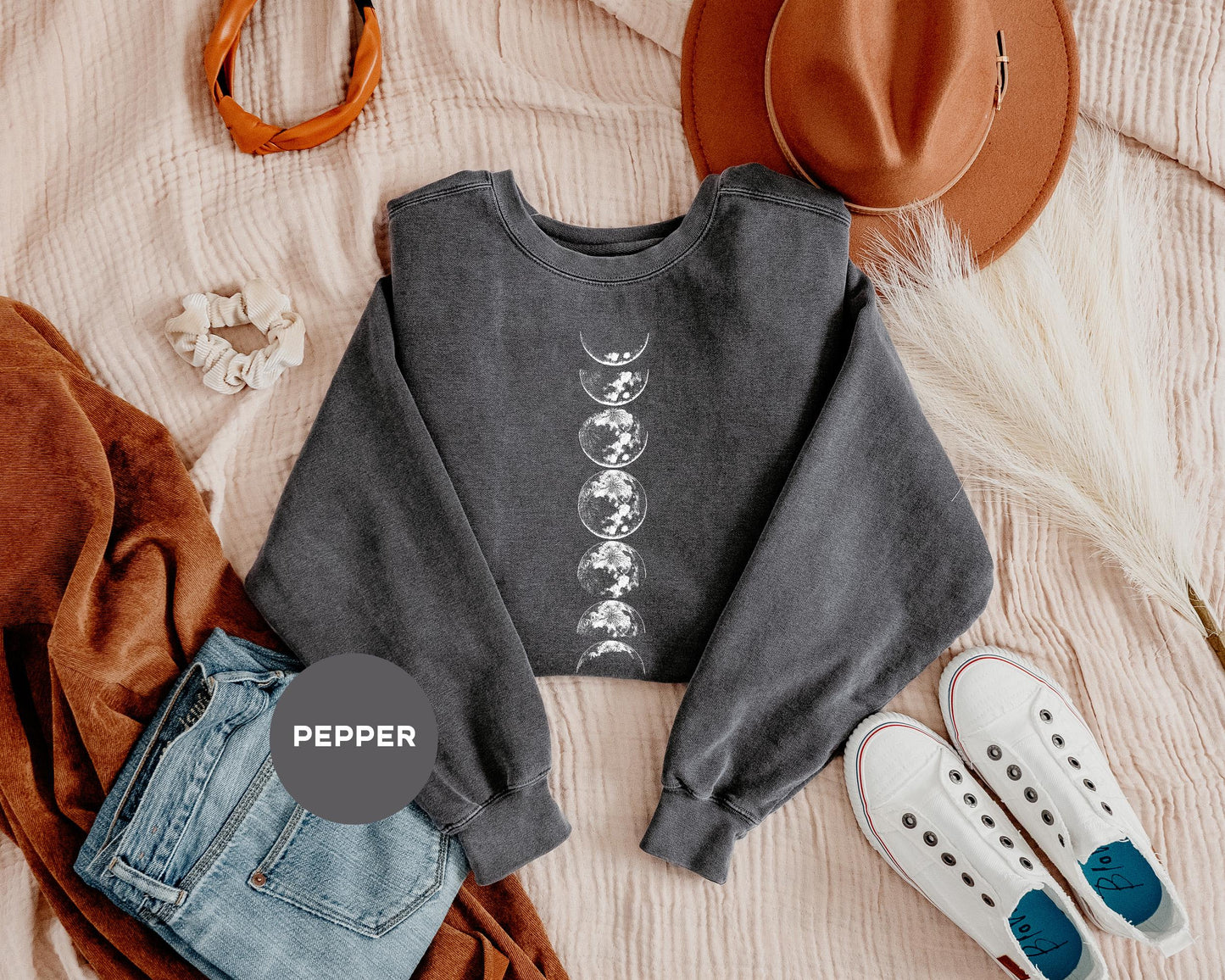 a crop top, jeans, hat, and slip on a bed