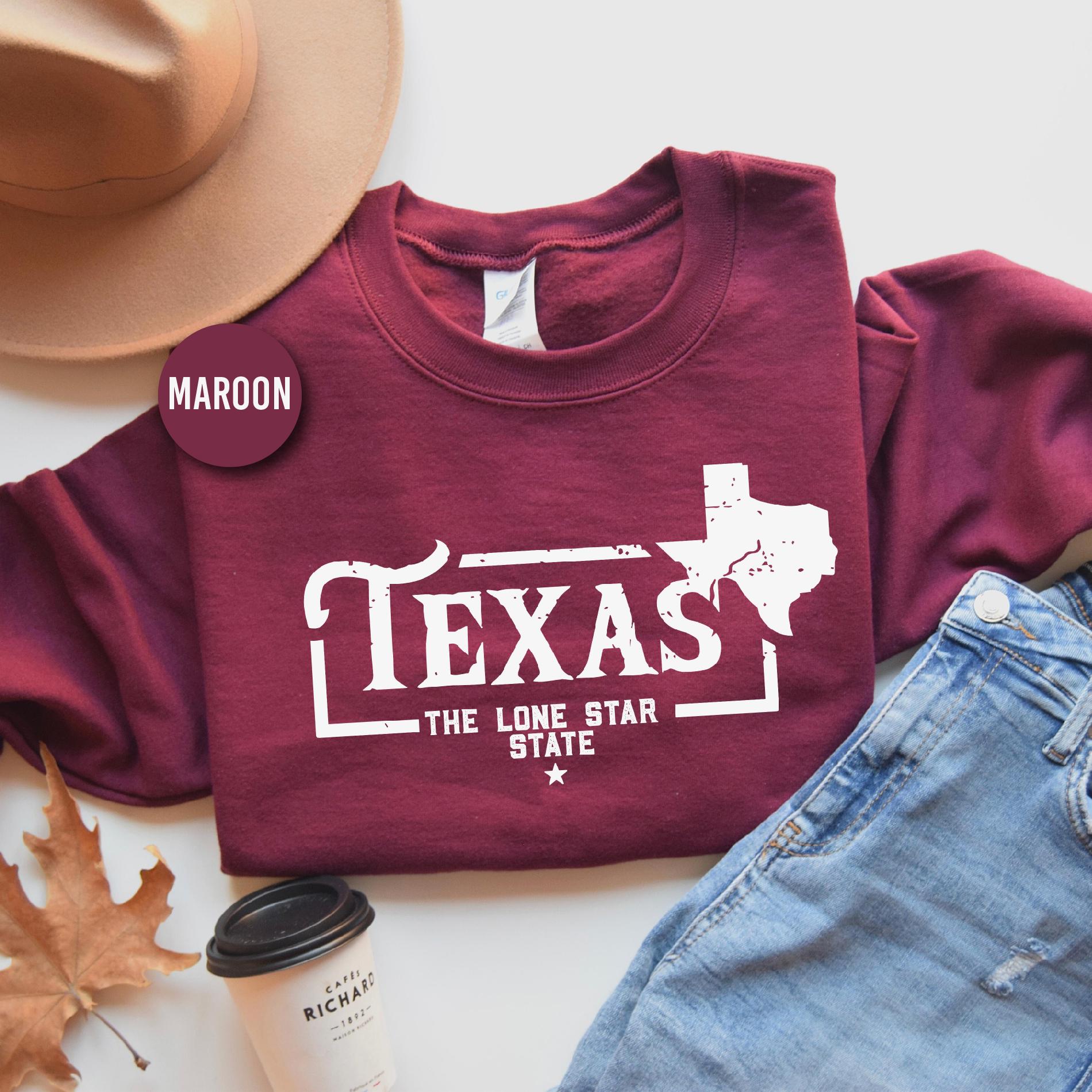 a maroon texas t - shirt with the lone star state on it