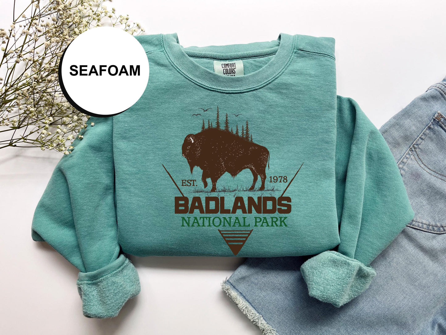 a t - shirt with a bison on it and a pair of jeans