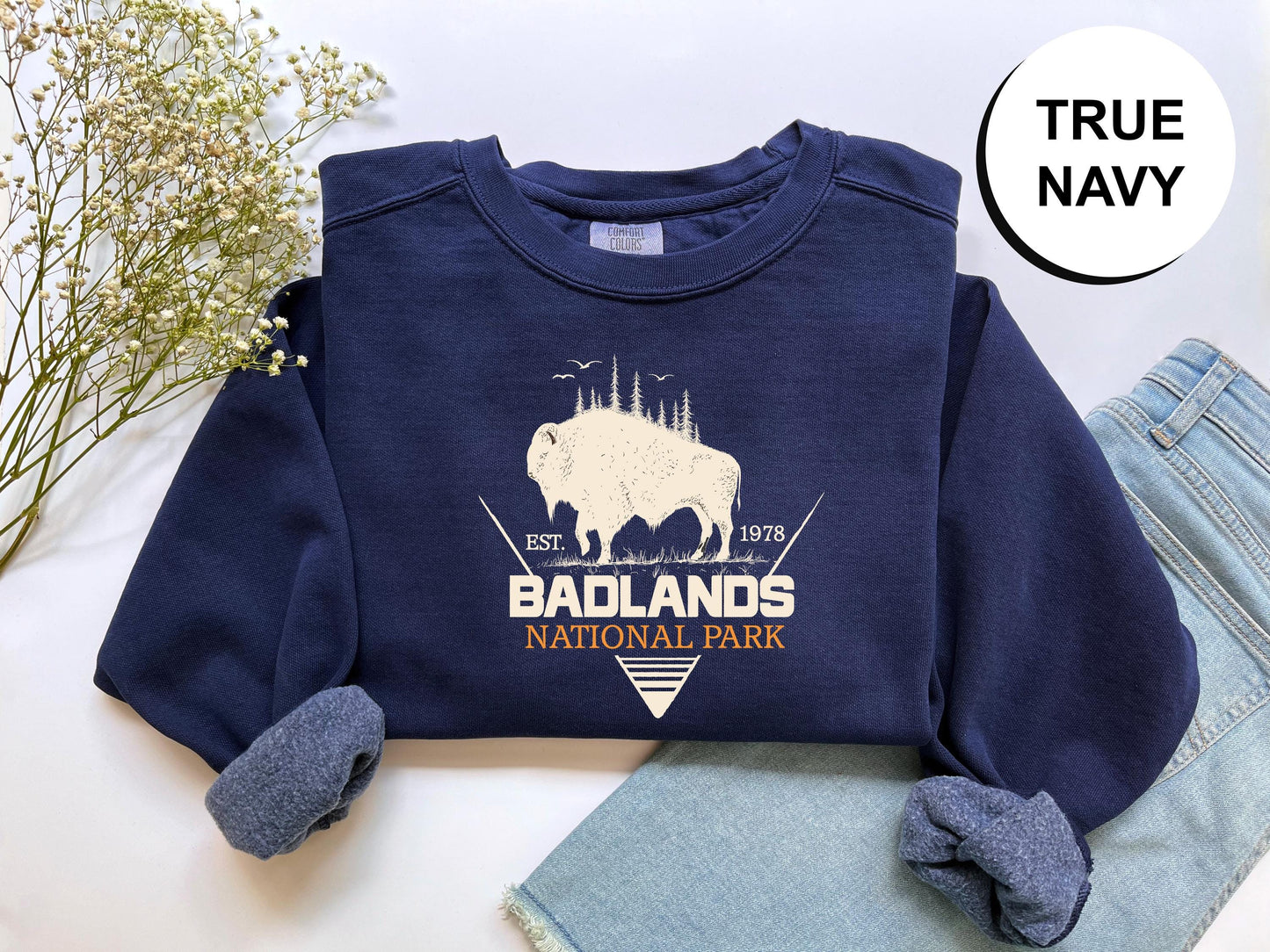 a blue shirt with a buffalo on it next to a pair of jeans