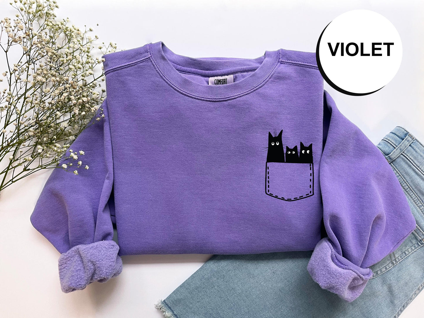 a purple shirt with a black cat in the pocket