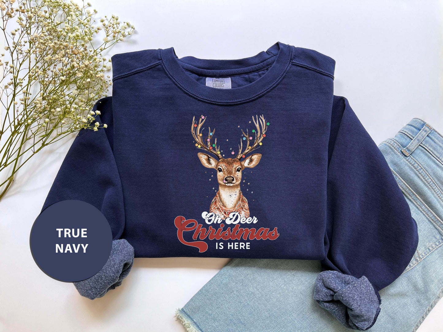 a blue shirt with a deer on it and a pair of jeans next to it