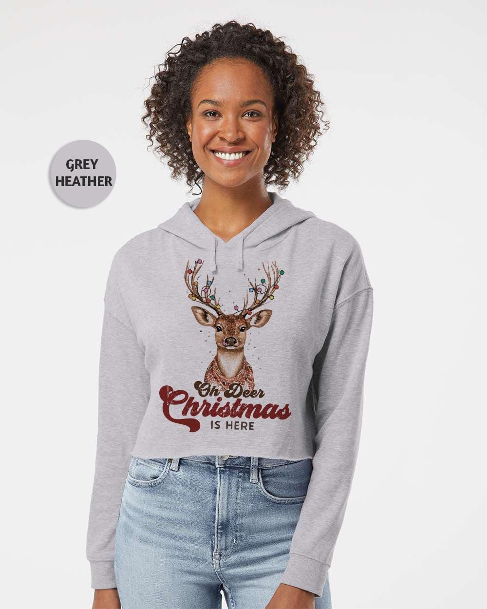 a woman wearing a grey sweatshirt with a deer on it
