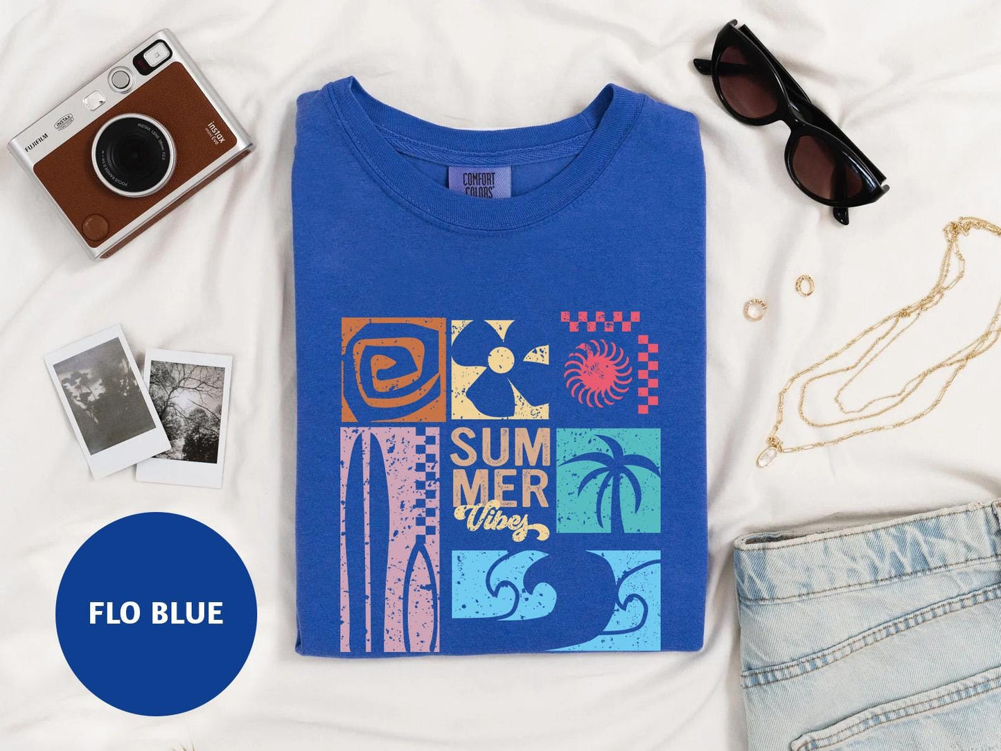 a blue t - shirt with a picture of a beach scene on it
