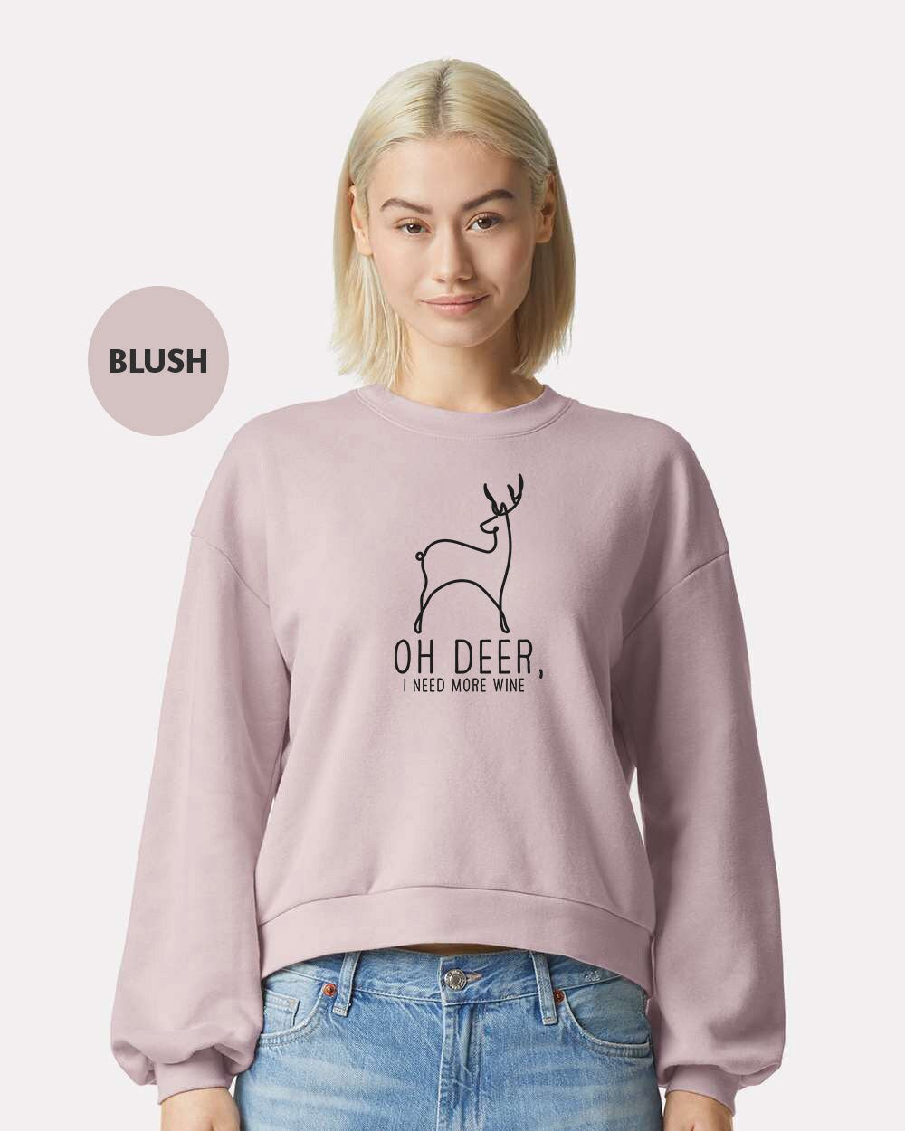 a woman wearing a pink sweatshirt with a deer on it