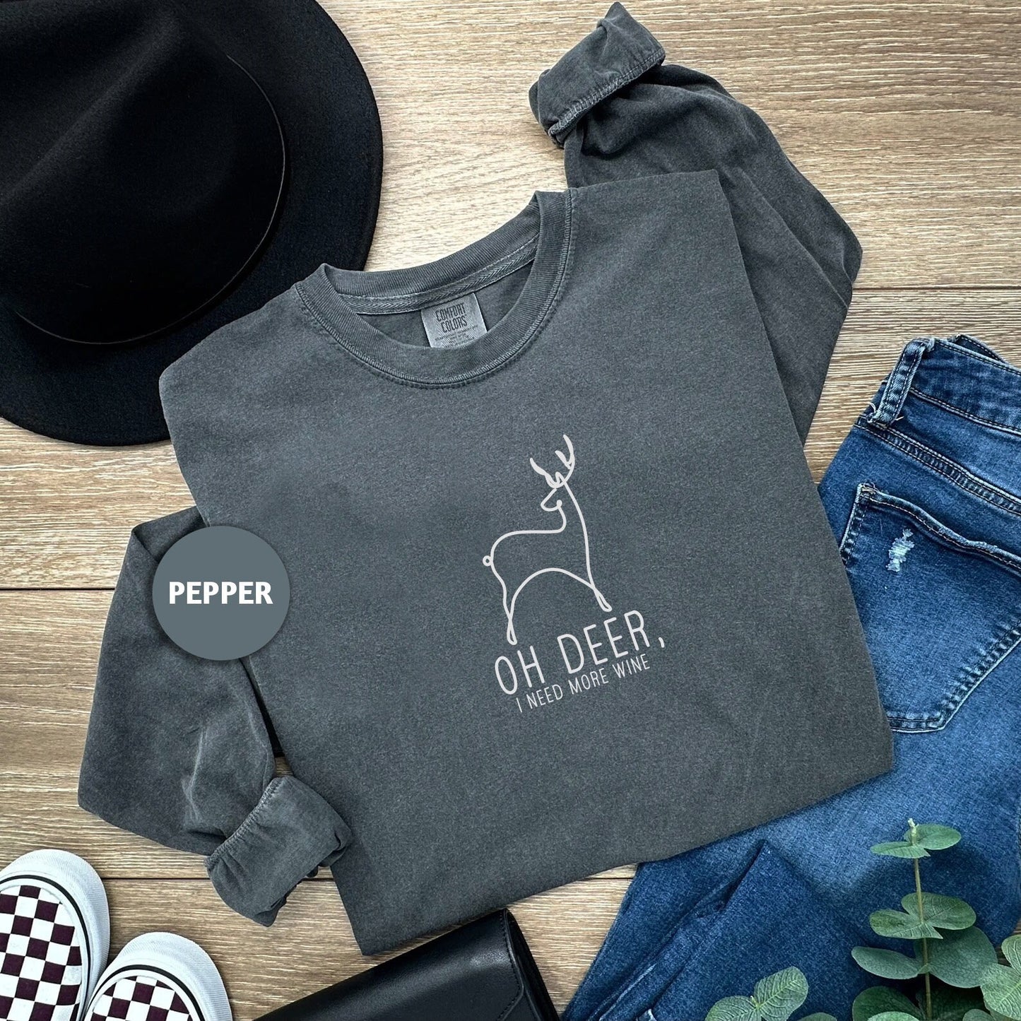 a pair of jeans, a hat, and a t - shirt on a wooden