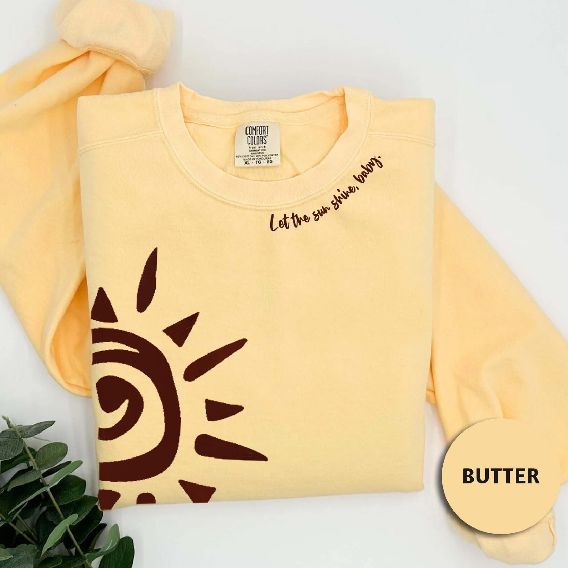 a yellow shirt with a brown sun on it
