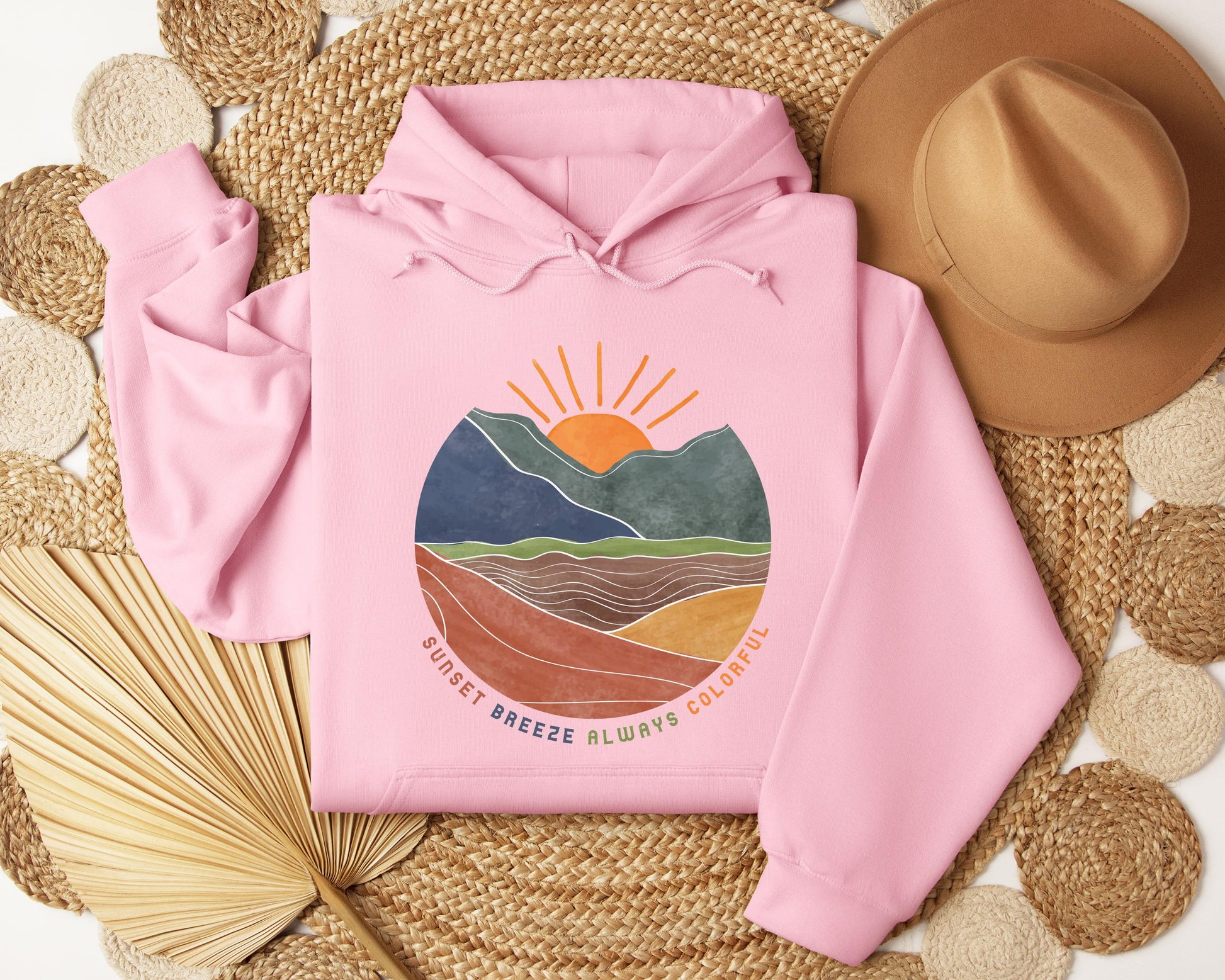 a pink hoodie sitting on top of a straw mat