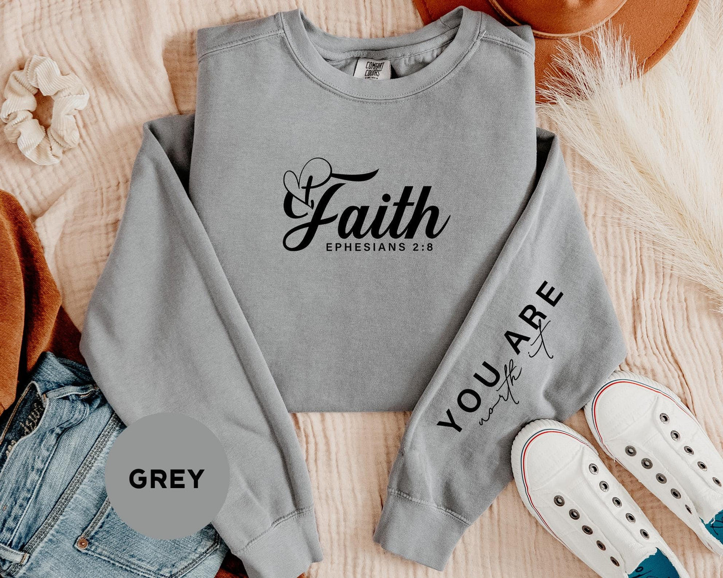 a grey sweatshirt with the words faith and a pair of white sneakers