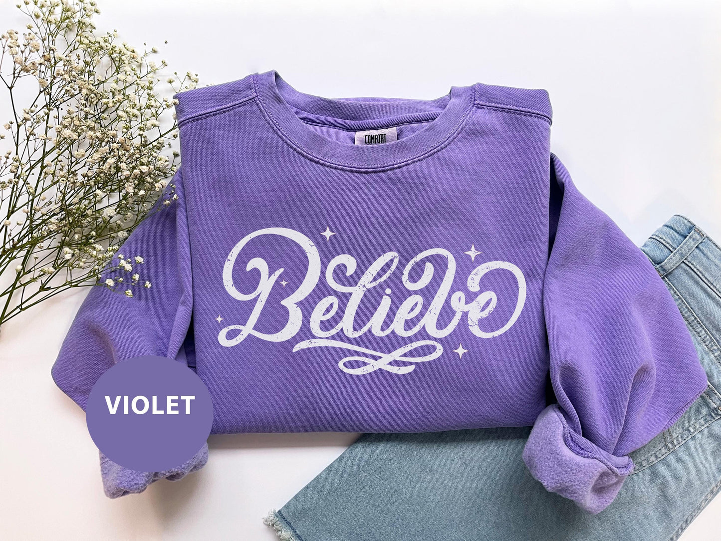 a purple sweatshirt with the word believe on it